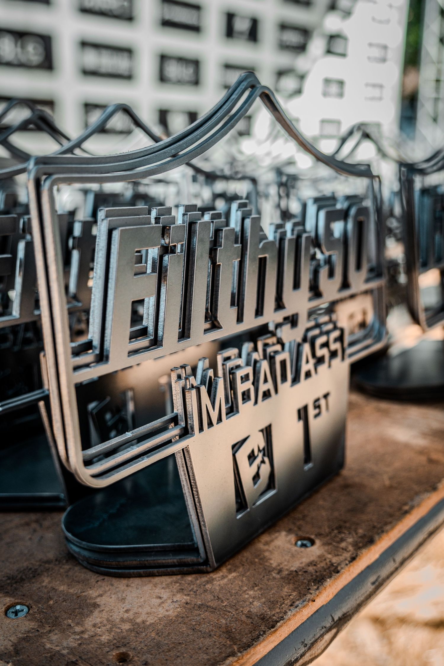 Metal signage with modern typography displayed on textured surface.