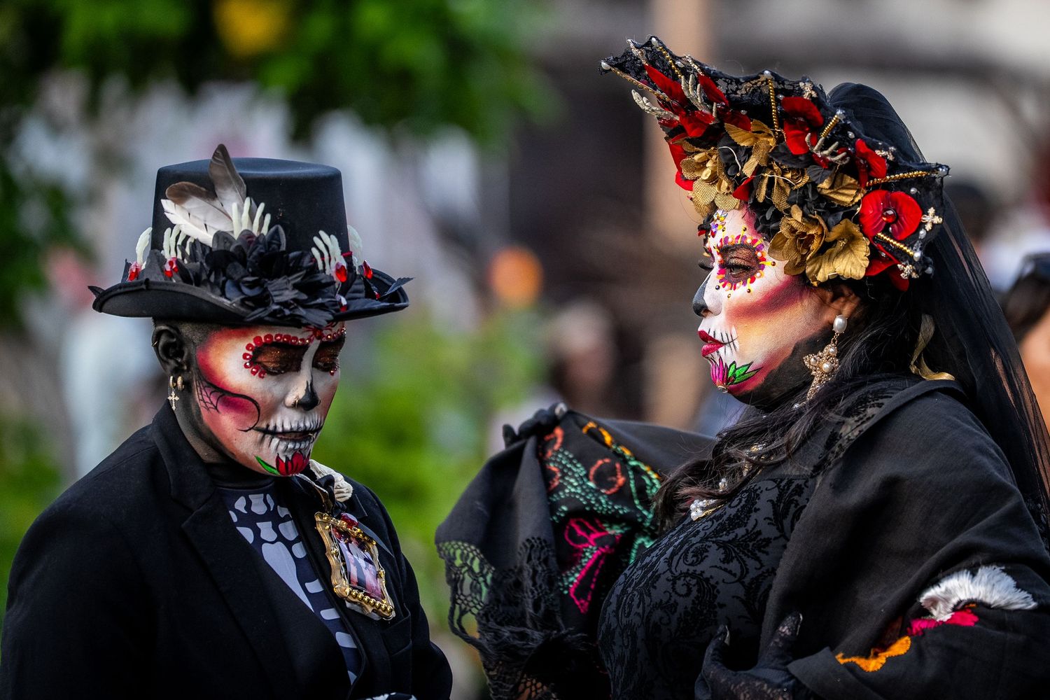 Day of the Dead celebration with ornate dark costumes and decorative skull makeup.