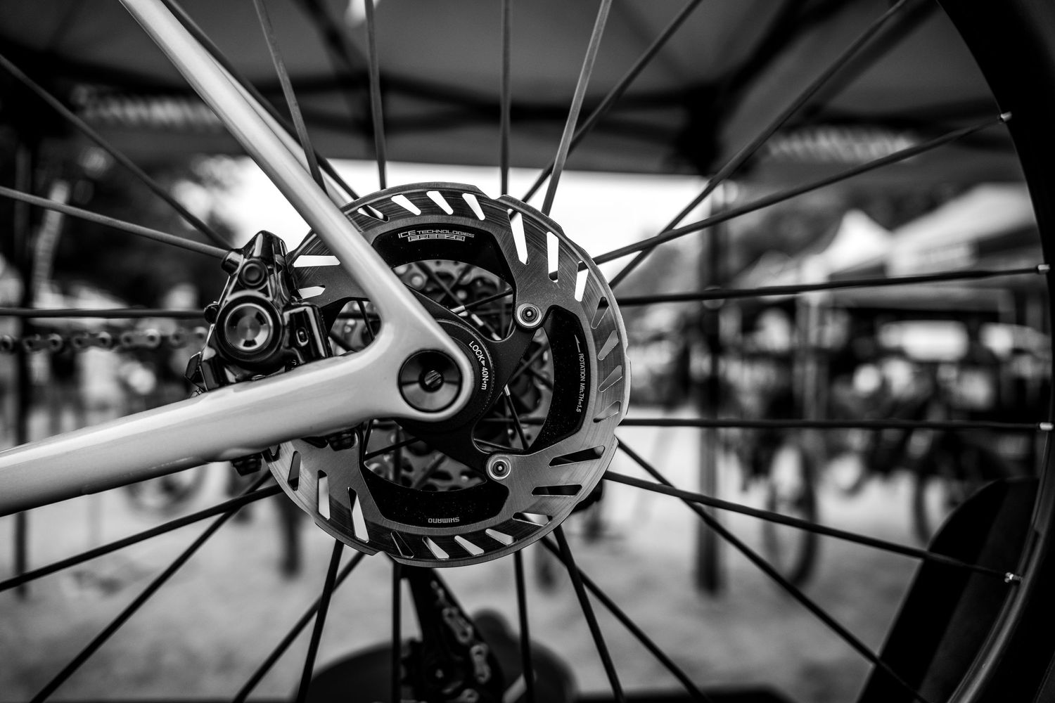 Close-up black and white photo of a bicycle disc brake and wheel hub.