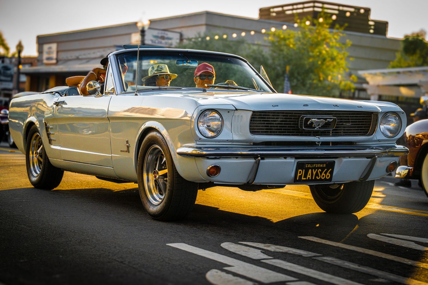 Classic silver Ford Mustang convertible parked in evening light.