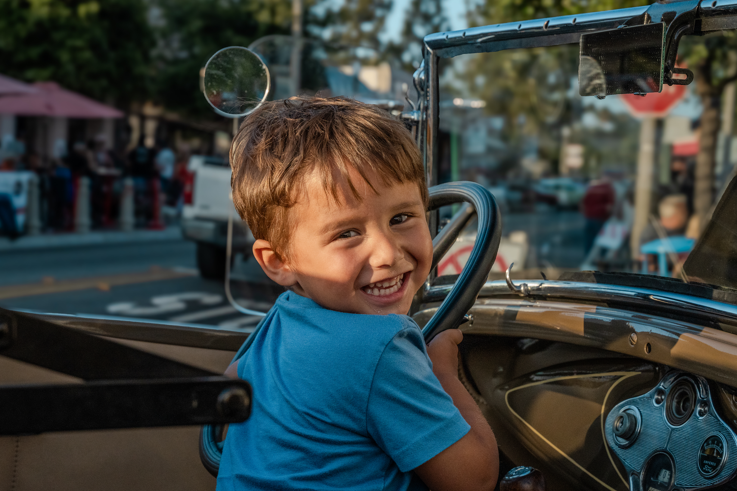 Child in blue shirt sitting in what appears to be a vehicle cockpit or dashboard.