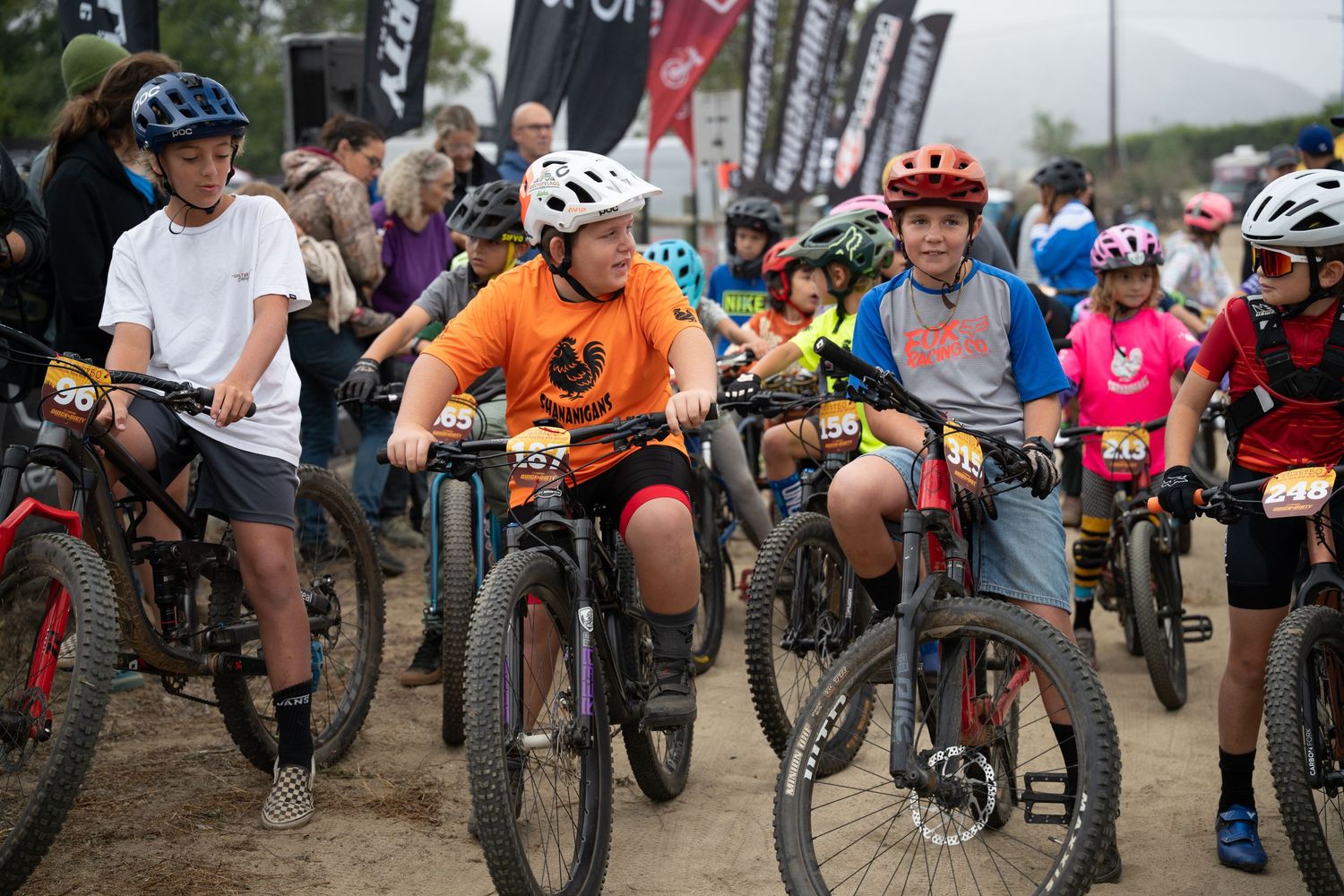 Group of mountain bikers lined up at the start of a race event.