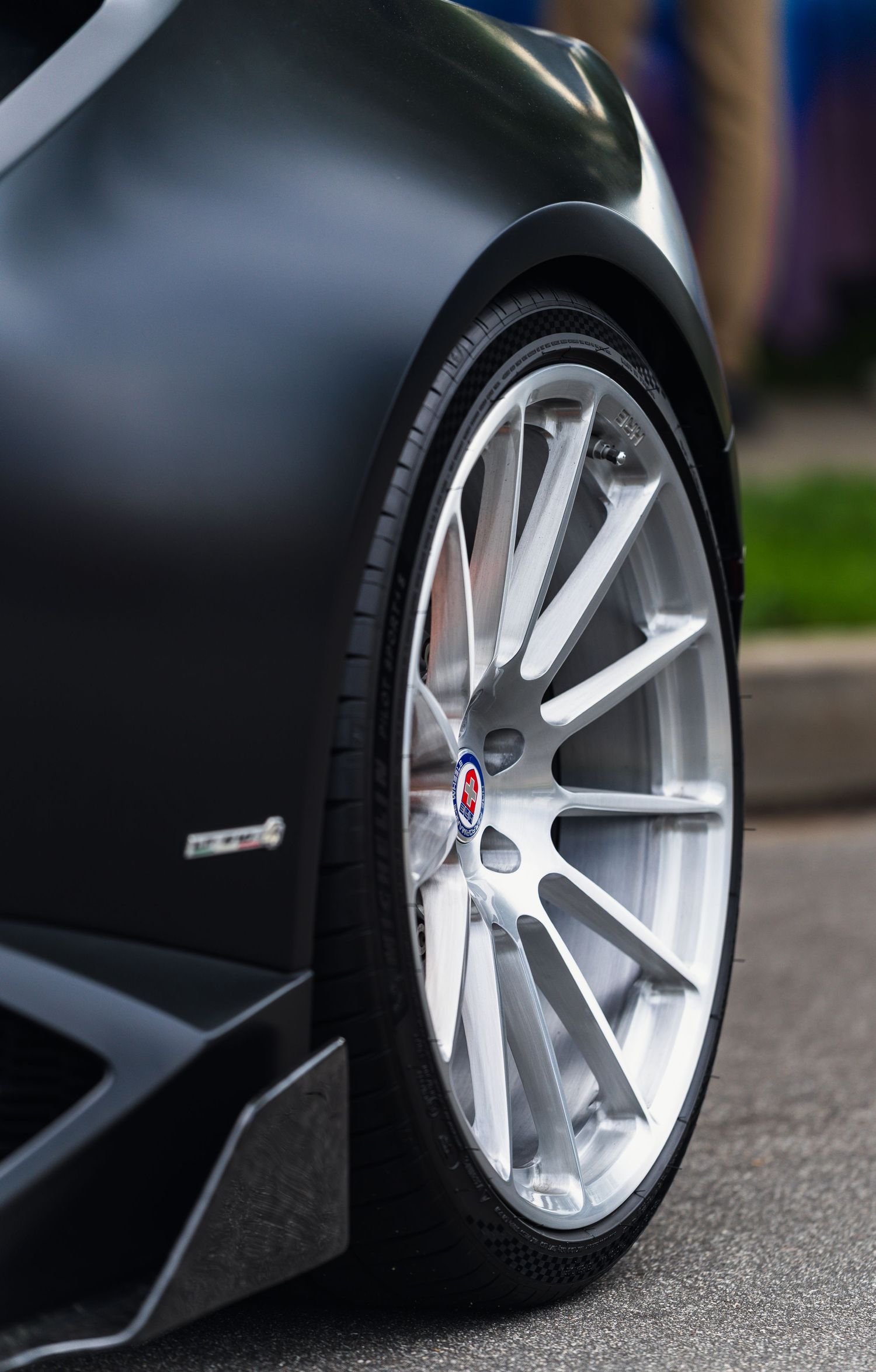 Close-up of luxury car wheel with silver alloy rim and performance tire.