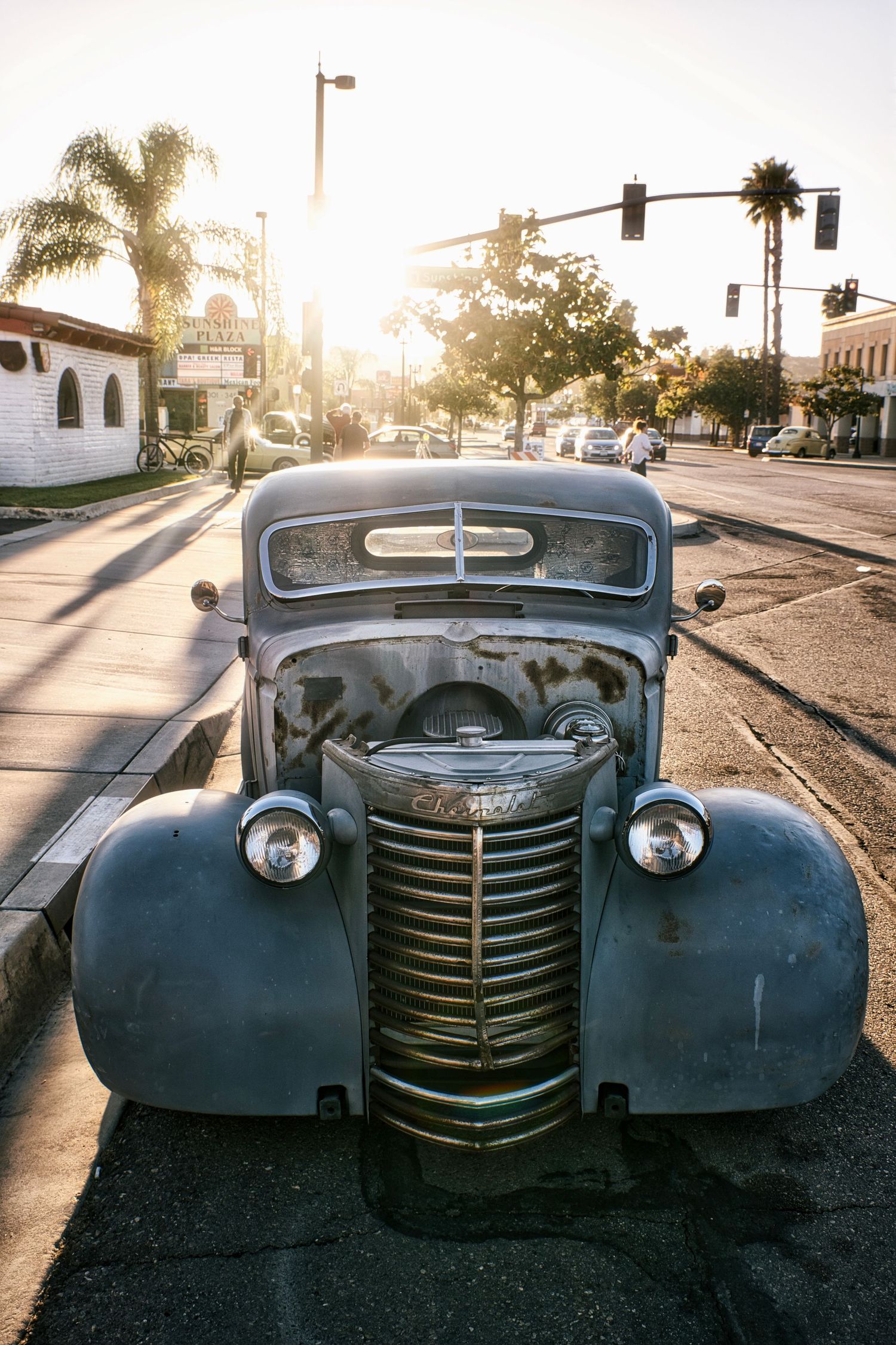 Vintage blue truck parked on a sunny street with palm trees and traffic lights in Santa Barbara, California.