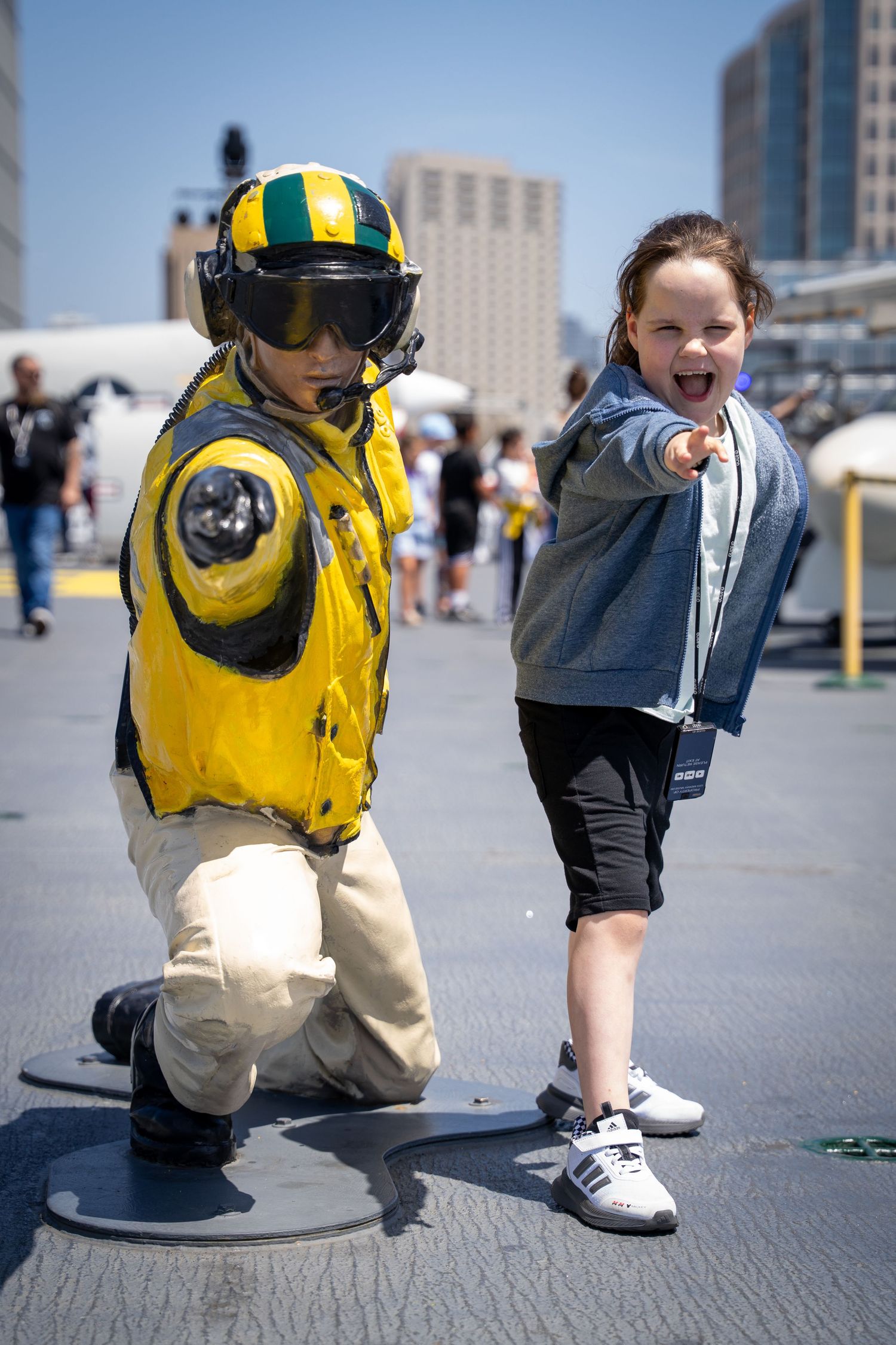 Small figure in yellow safety gear exploring outdoor urban environment.
