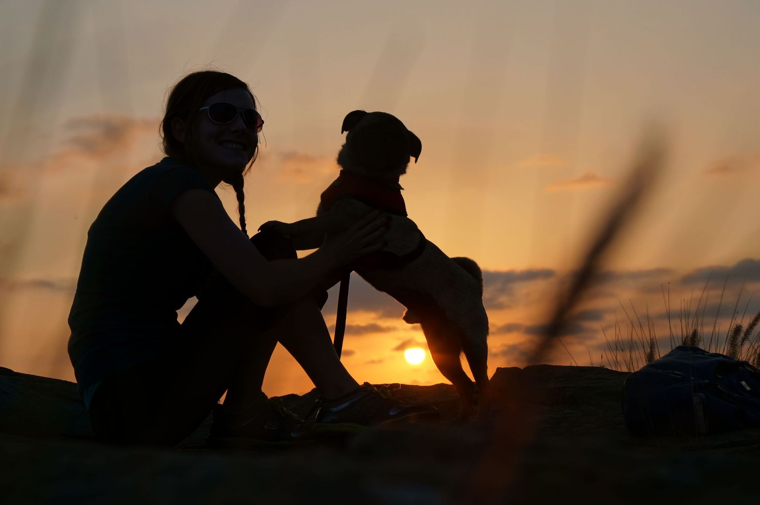 Silhouettes of people sitting together watching a golden sunset.