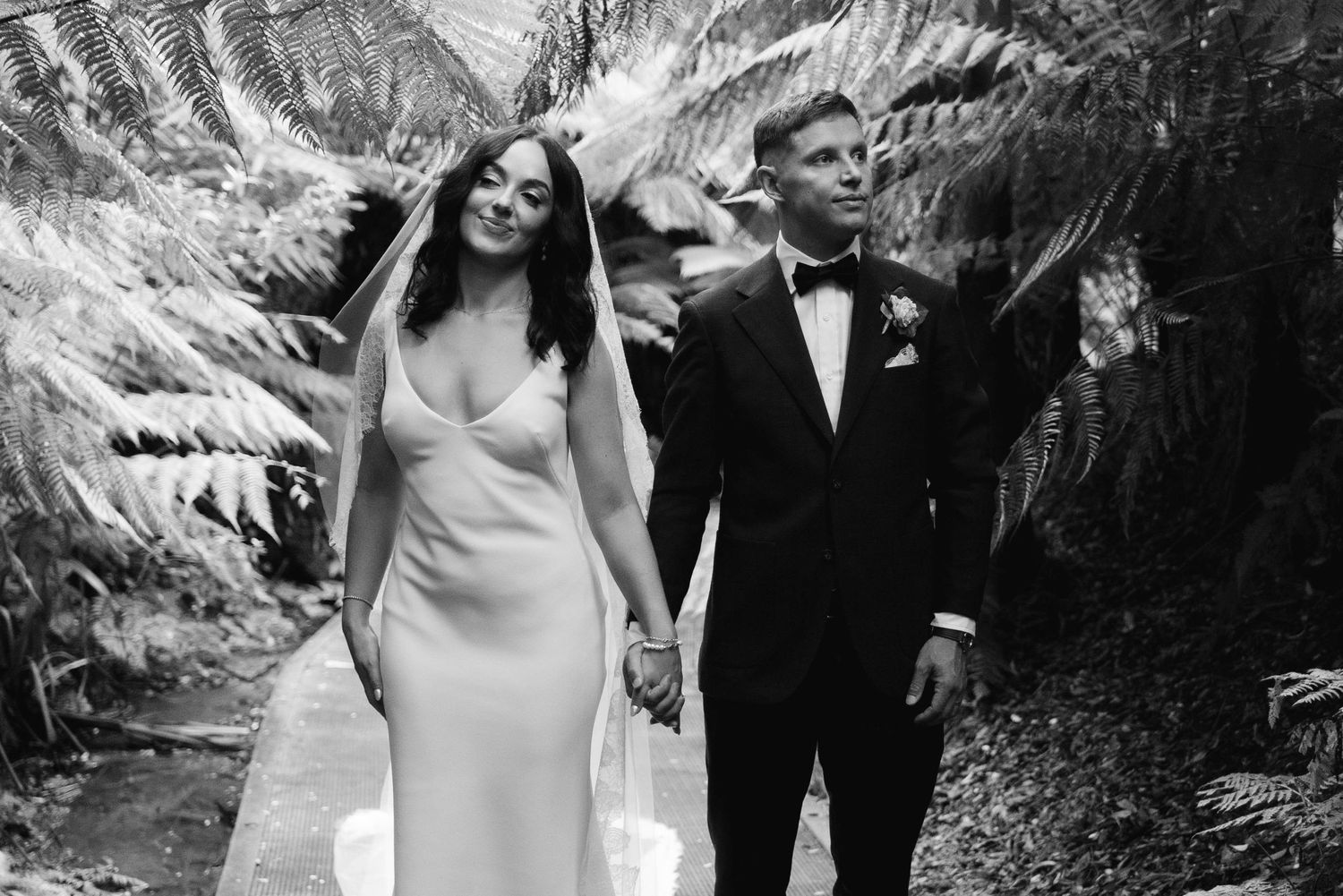 A bride and groom share romantic moments while posing together in front of a dramatic mountain landscape.