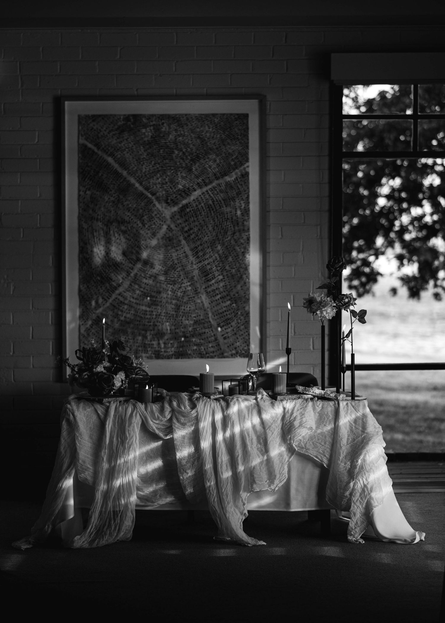 White linens hanging on a clothesline in front of windows creating dramatic shadows and light.