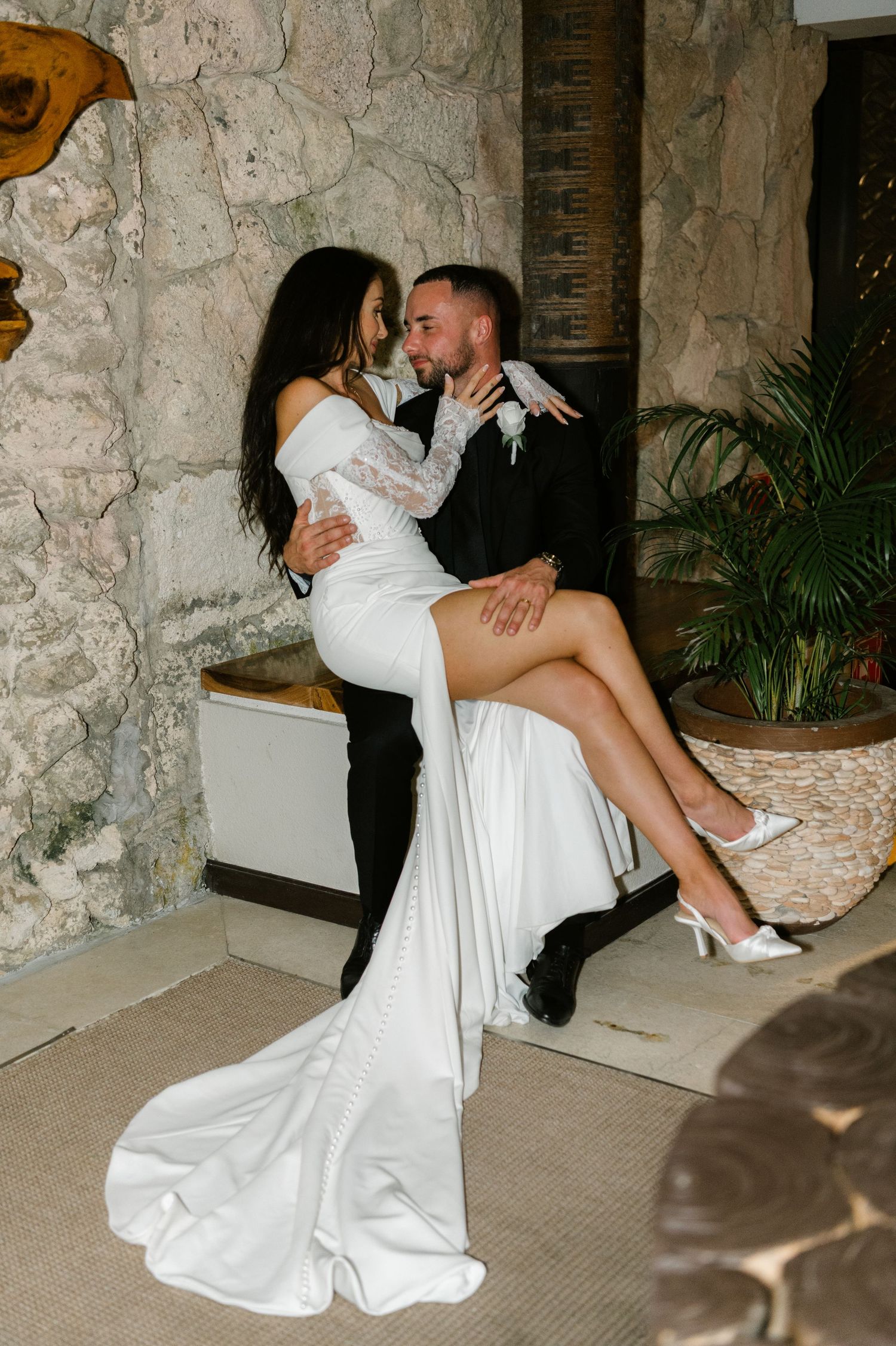 A sequence of romantic wedding photos showing a couple in intimate poses against a stone wall backdrop.
