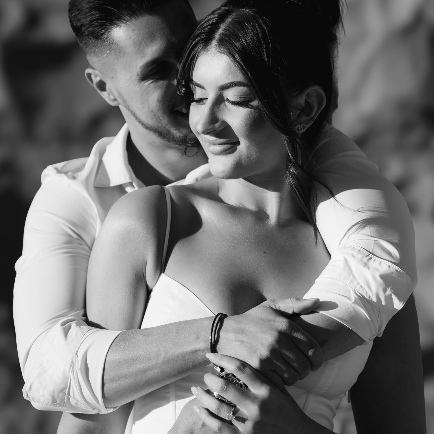 Two people share an intimate embrace while wearing white clothing.
