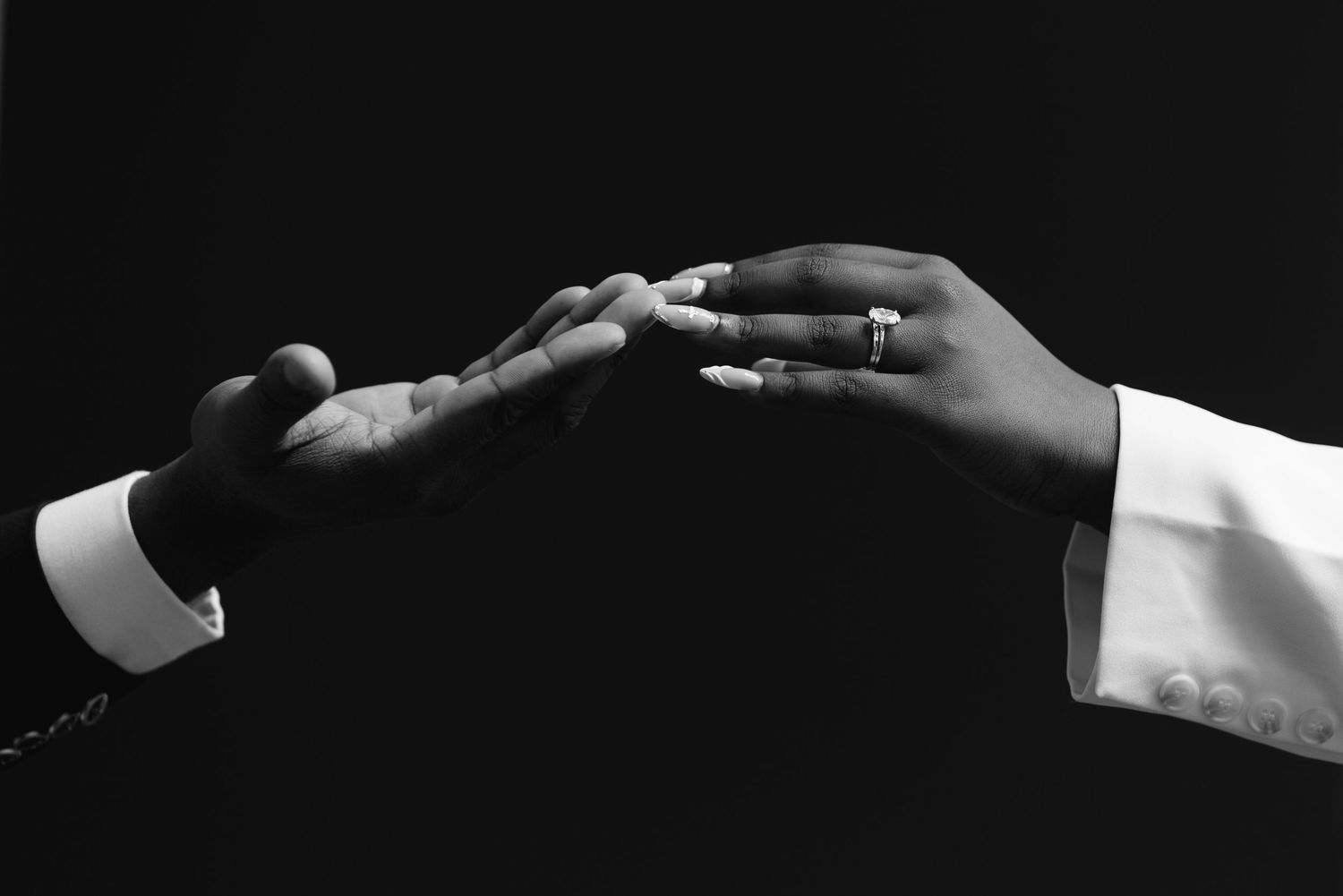 Artistic black and white photo of hands joining together in unity.