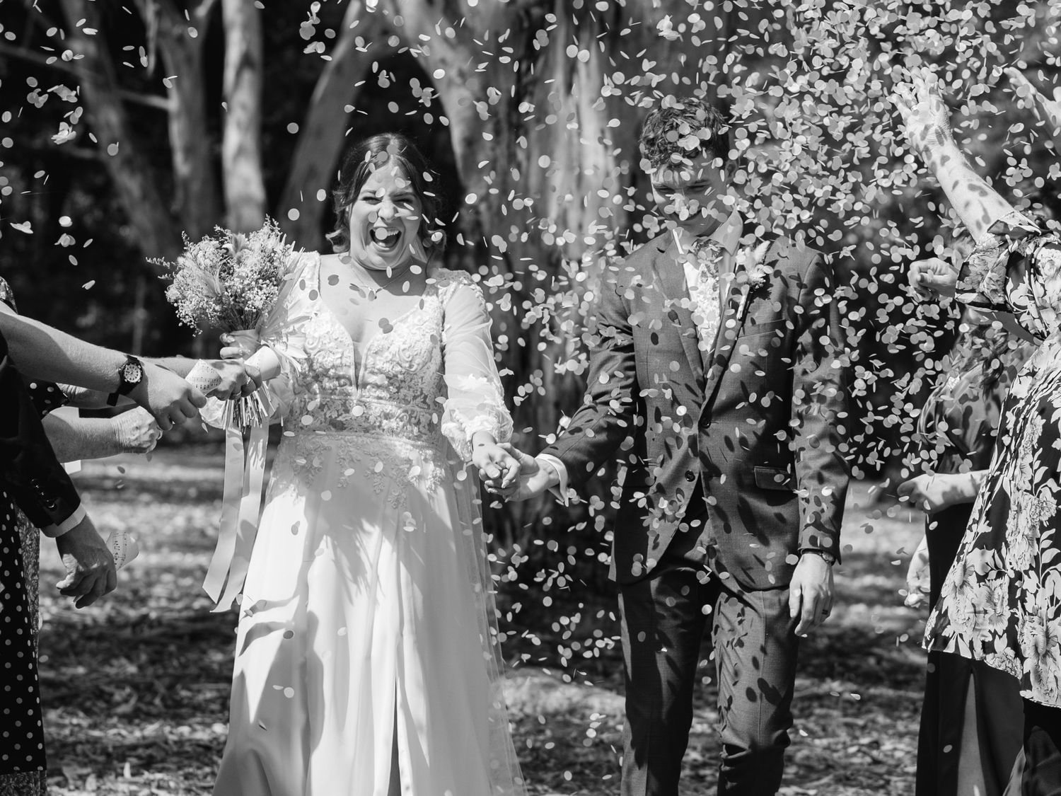 Wedding celebration with confetti shower in black and white.