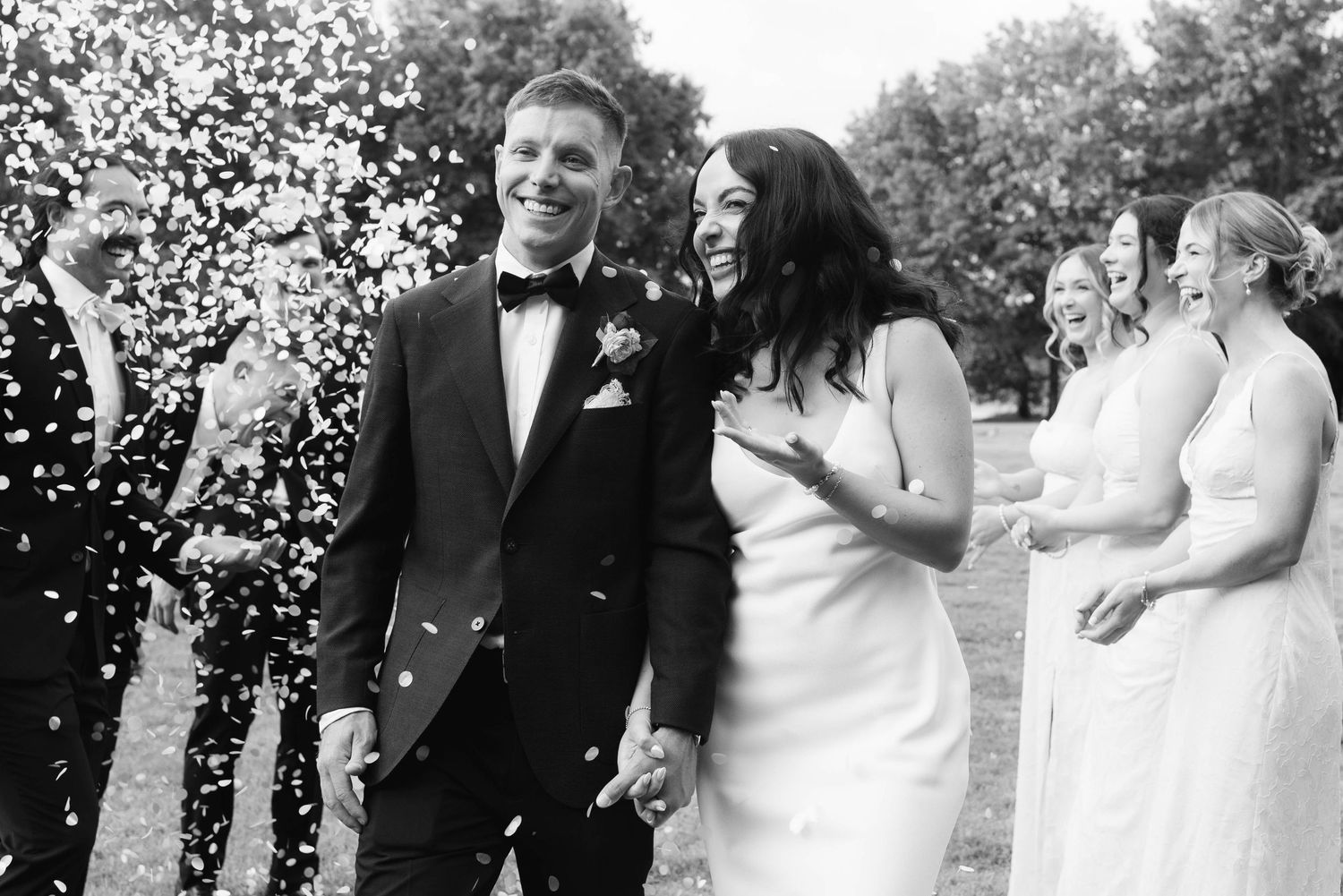 A black and white photo collage of wedding moments showing couples celebrating outdoors with confetti and natural scenery.