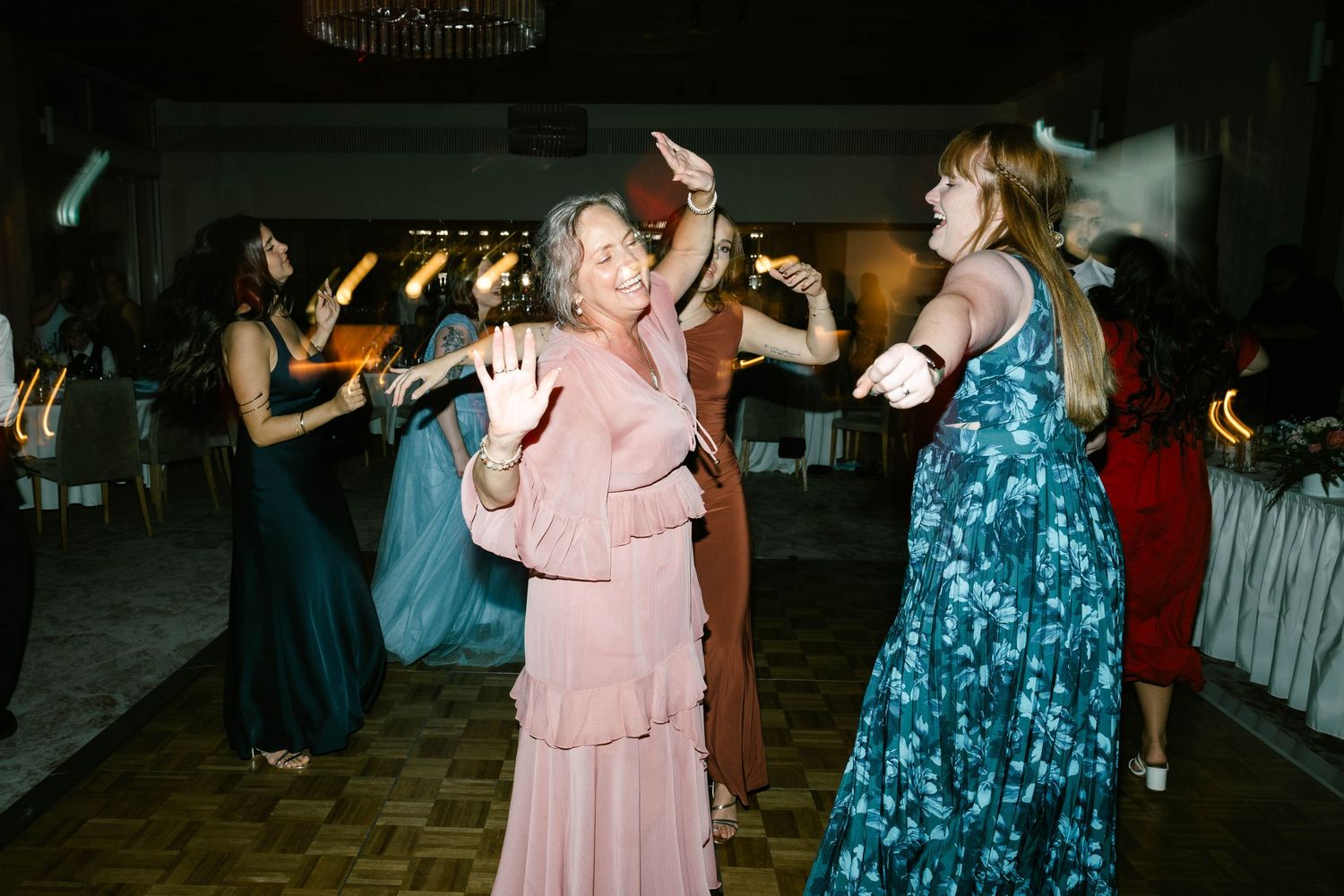 People dancing and celebrating at a wedding reception with atmospheric fog and elegant lighting effects.