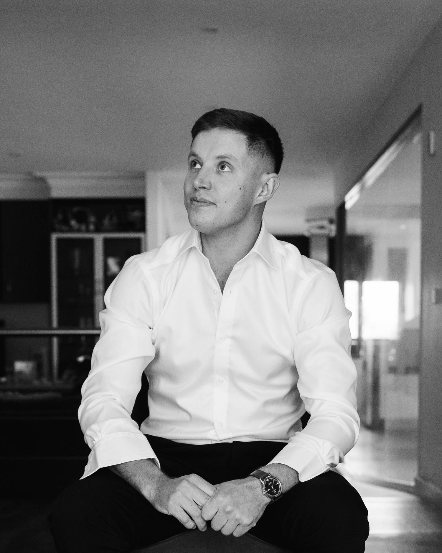 Black and white portrait series showing a person in a white dress shirt sitting against a light background.