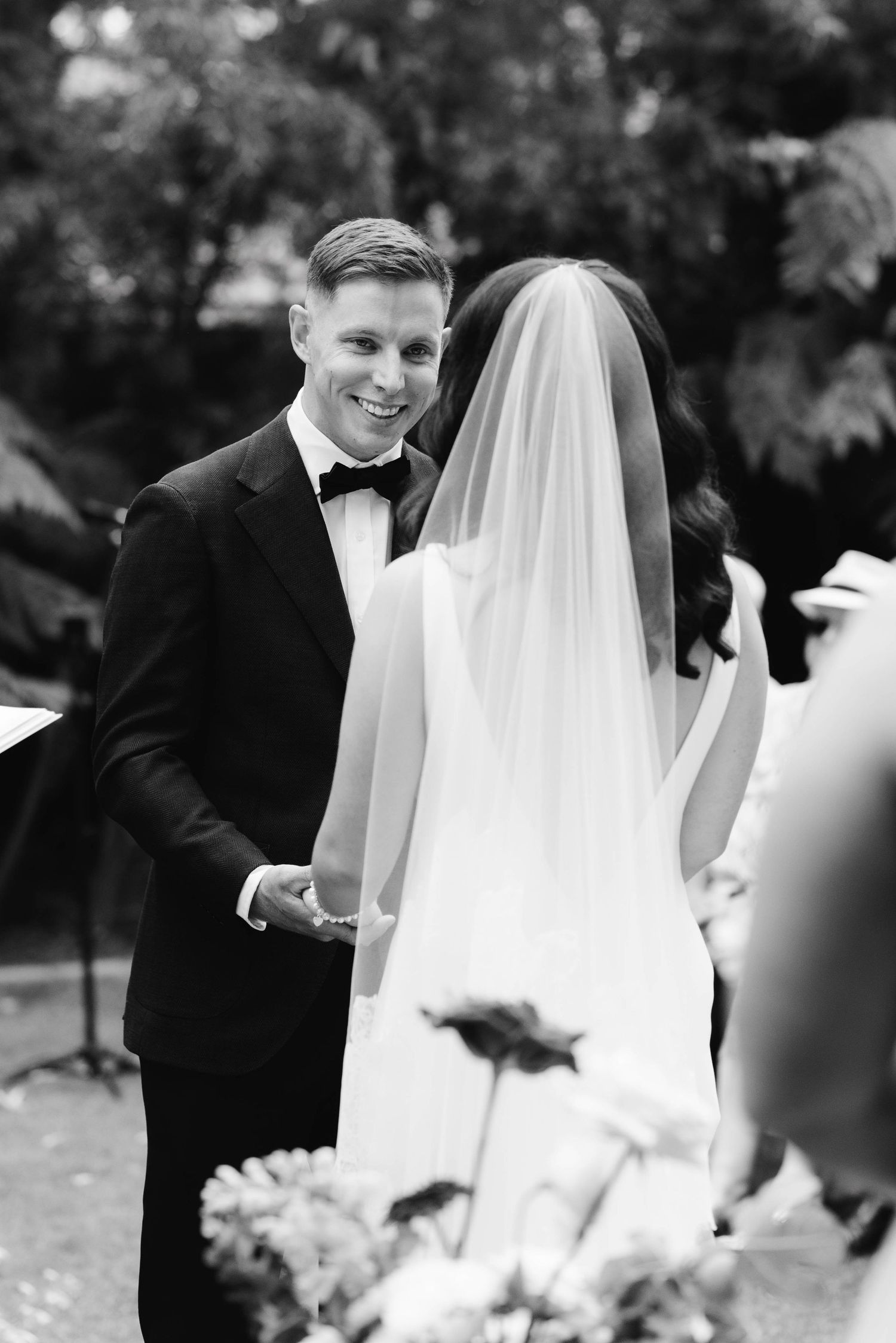 A series of black and white wedding photos showing tender moments between a bride and groom in an outdoor setting.