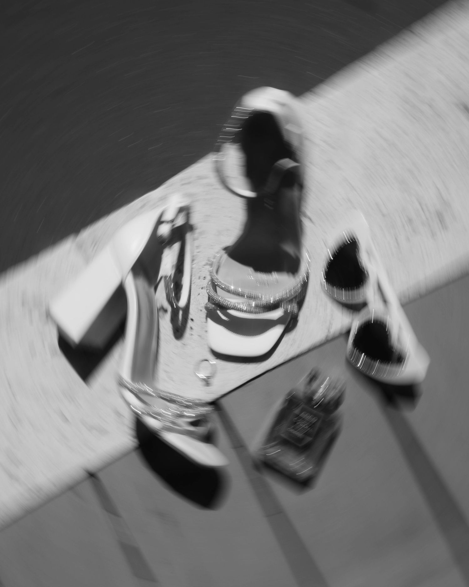 Black and white photo of glass bottles with motion blur creating an artistic abstract composition.