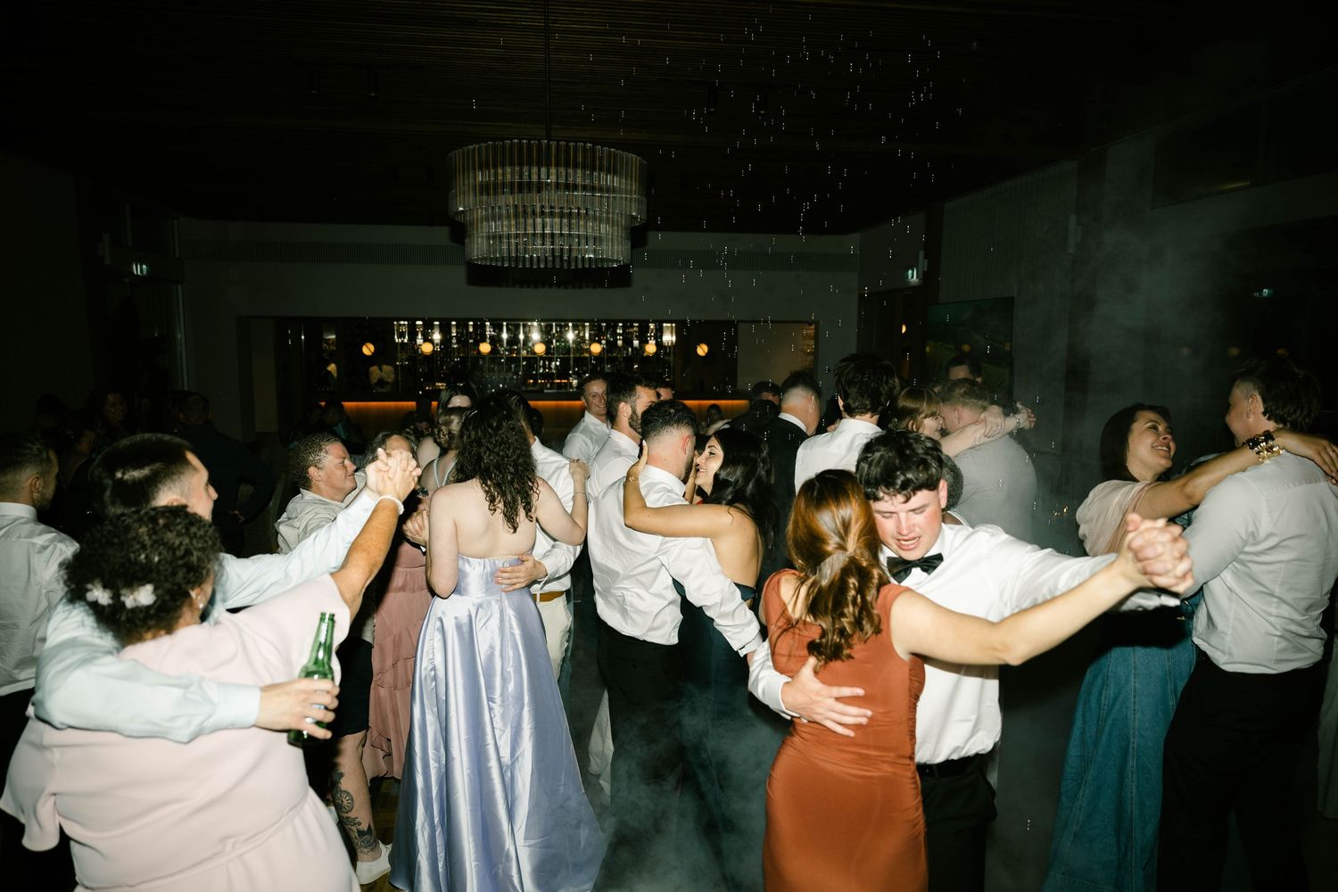 A sequence of blurry dance floor photos showing people dancing and celebrating at a dimly lit party venue.