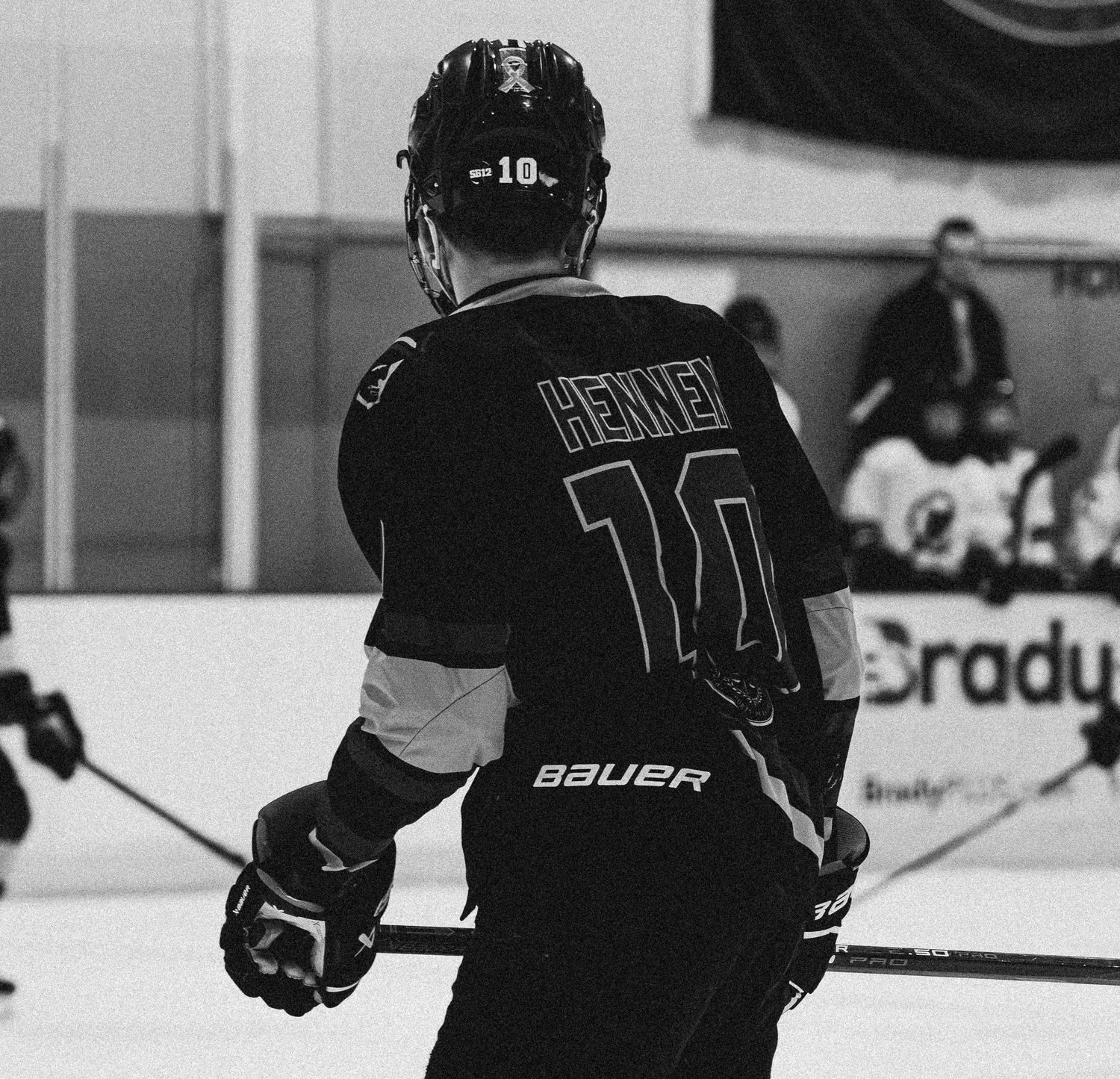 Hockey player wearing number 14 jersey seen from behind on the ice.