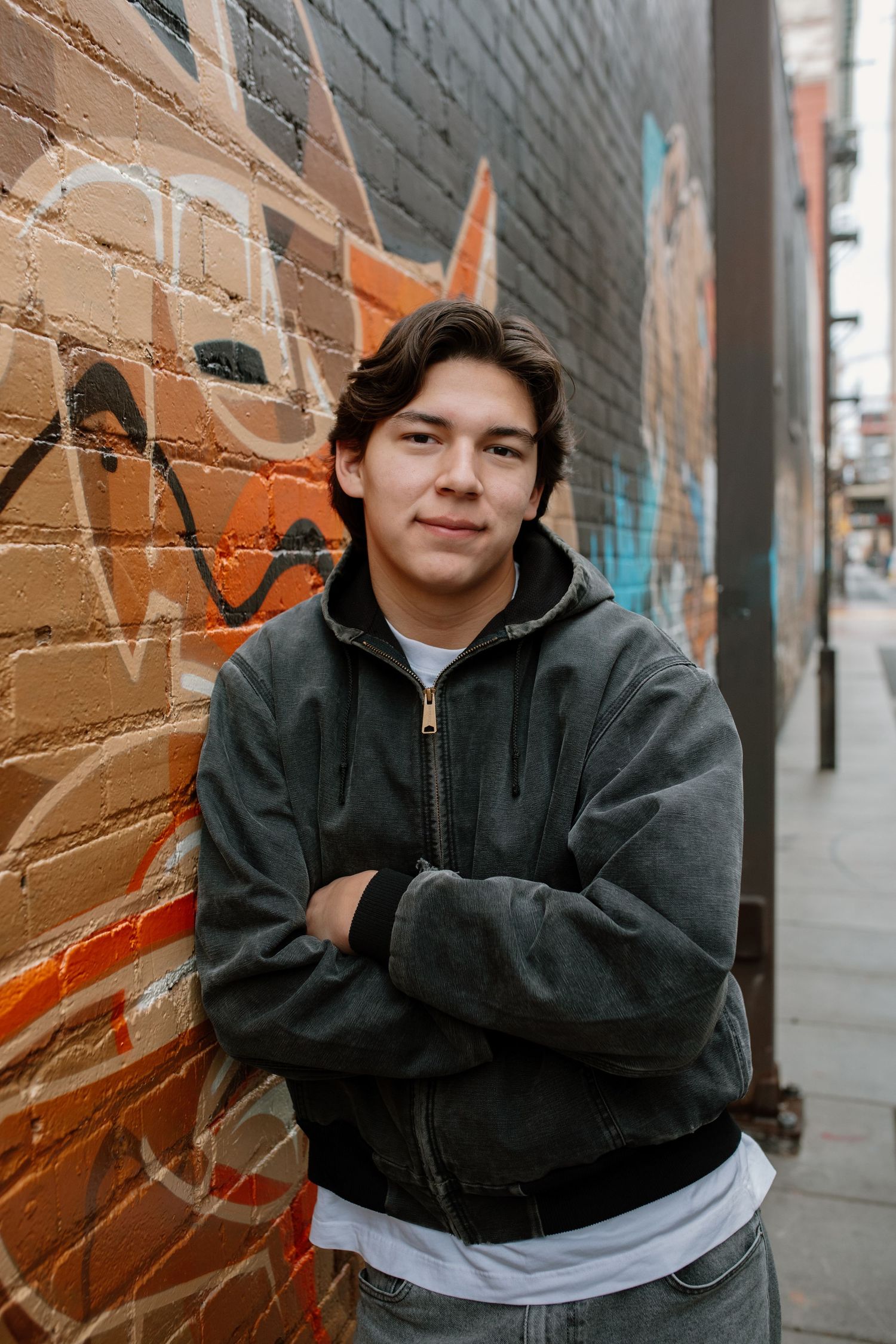 Urban portrait series against a brick wall featuring casual attire and natural lighting in an urban setting.