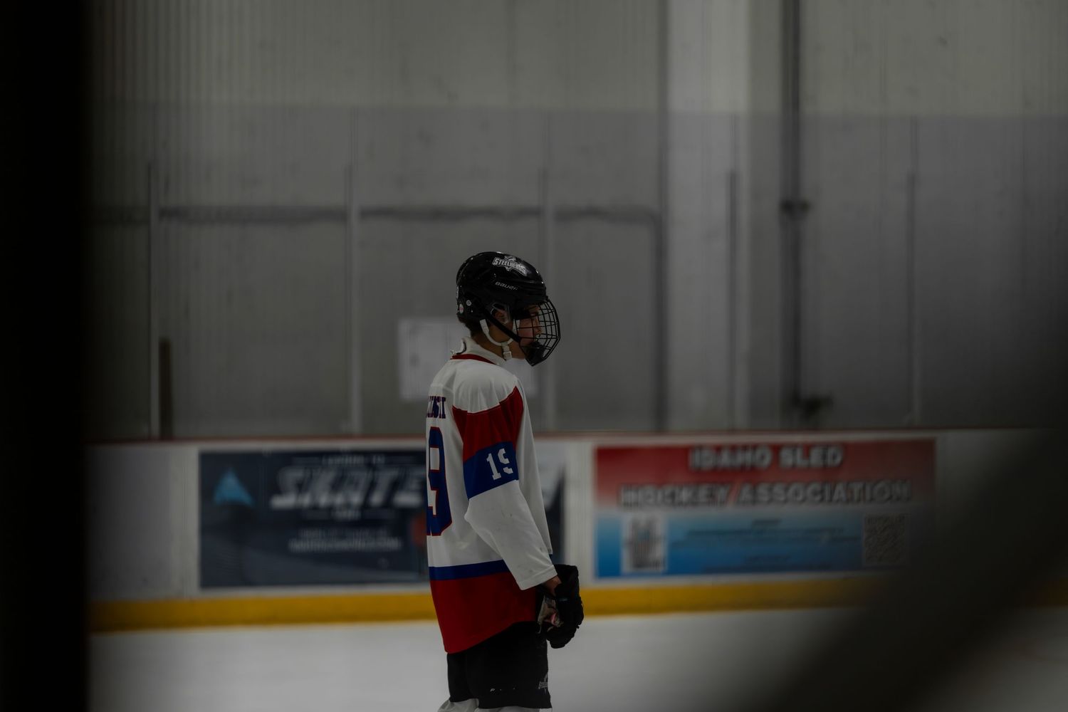 Hockey players practicing drills and skating techniques on an indoor ice rink during training session.