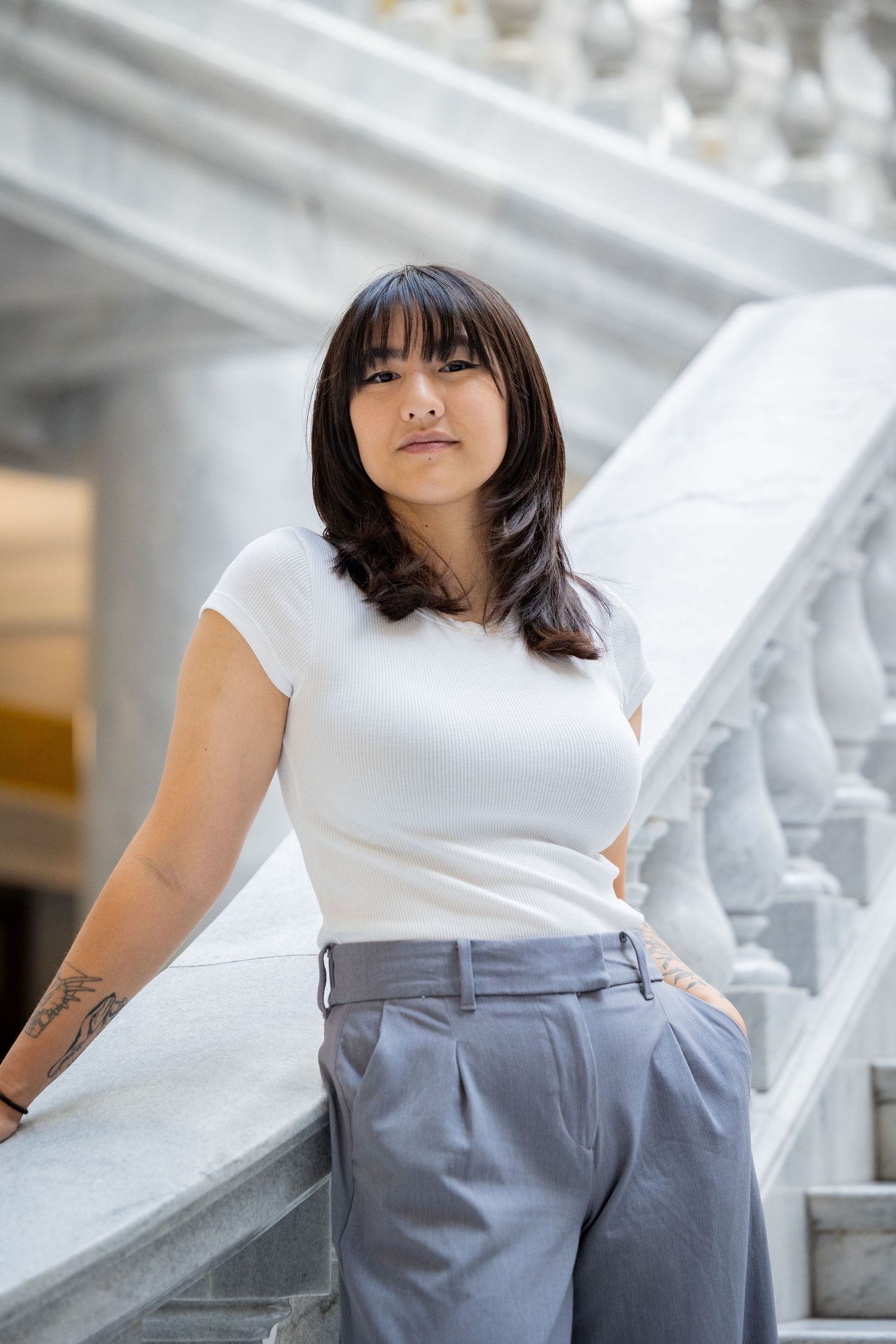 Lifestyle photography with white top and gray pants in an elegant marble interior setting.