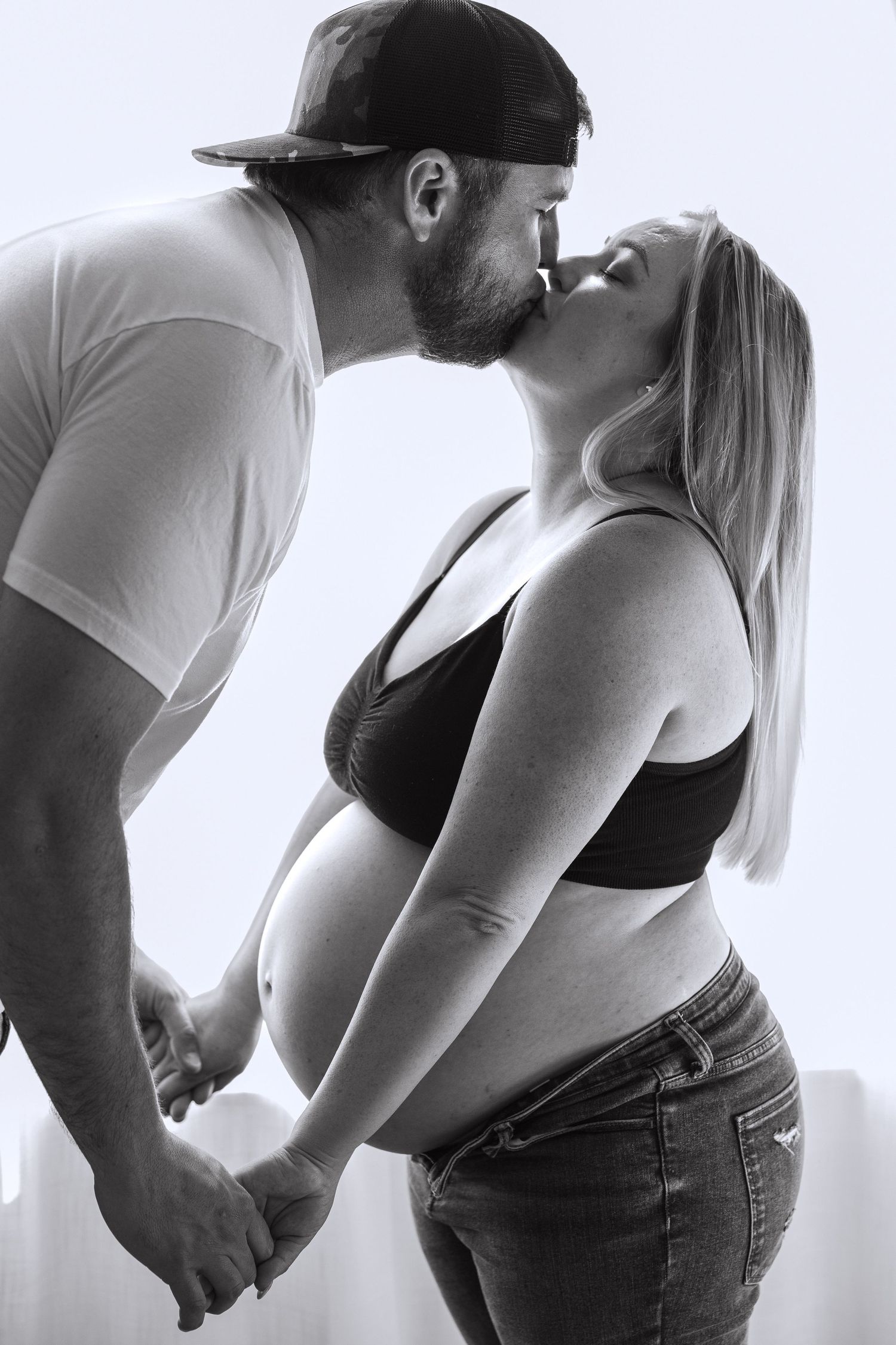 Black and white maternity photos showing intimate moments between a couple.