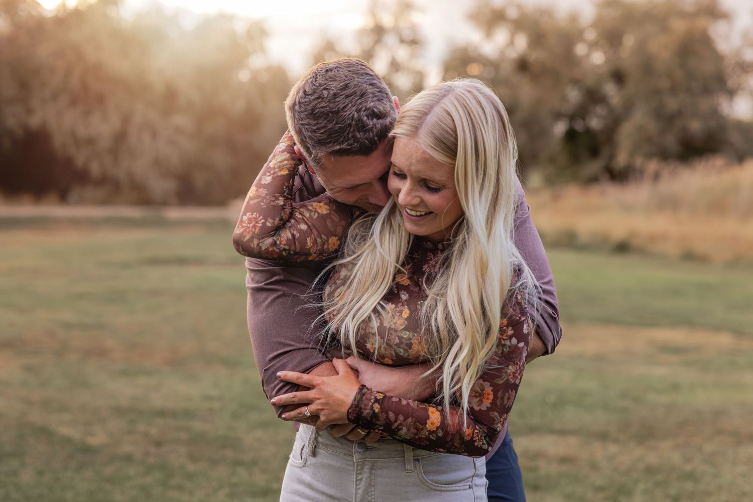 Romantic couple sharing intimate moments during outdoor photo session at dusk.