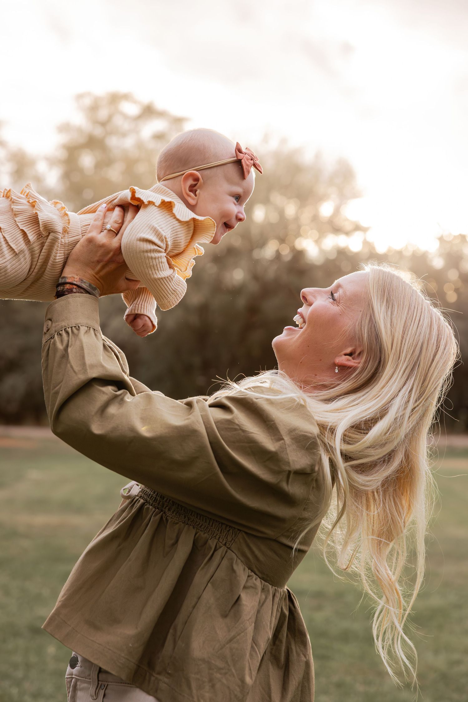 A joyful moment captured between parent and child playing in warm sunset light.