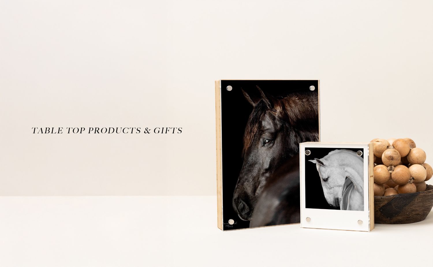 Elegant black and white photography studio setup with product displays and portfolio samples on wall.
