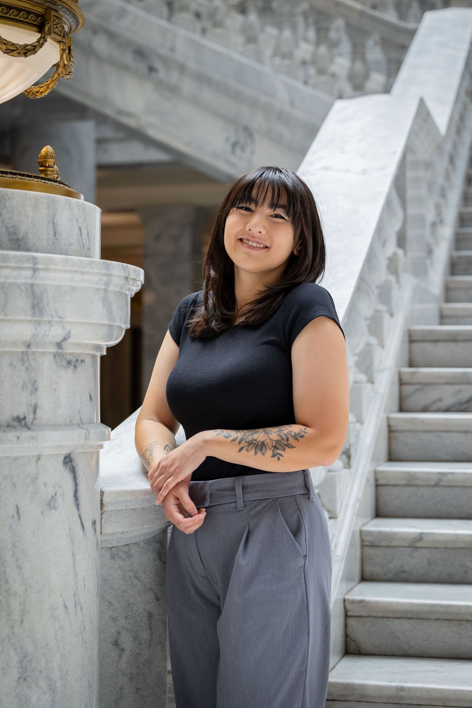 Casual business portraits taken on marble steps with natural lighting.
