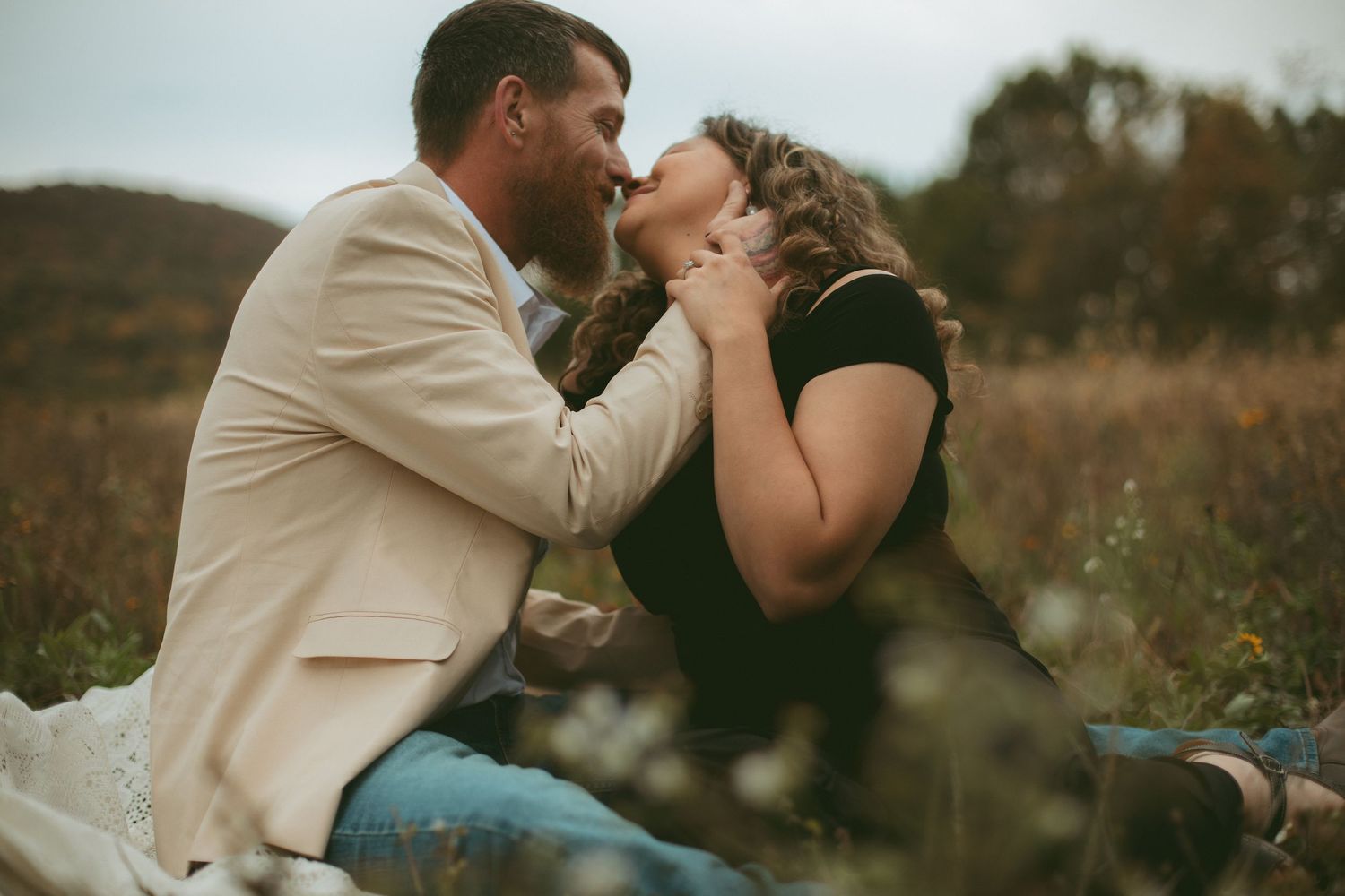 Romantic couple embracing in an outdoor setting during sunset.
