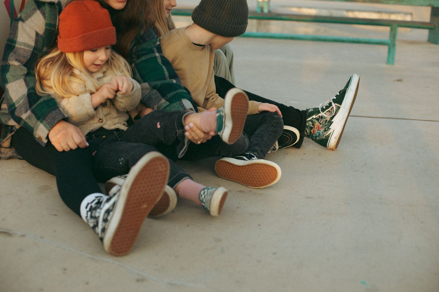 People sitting close together on a concrete floor wearing casual clothes.