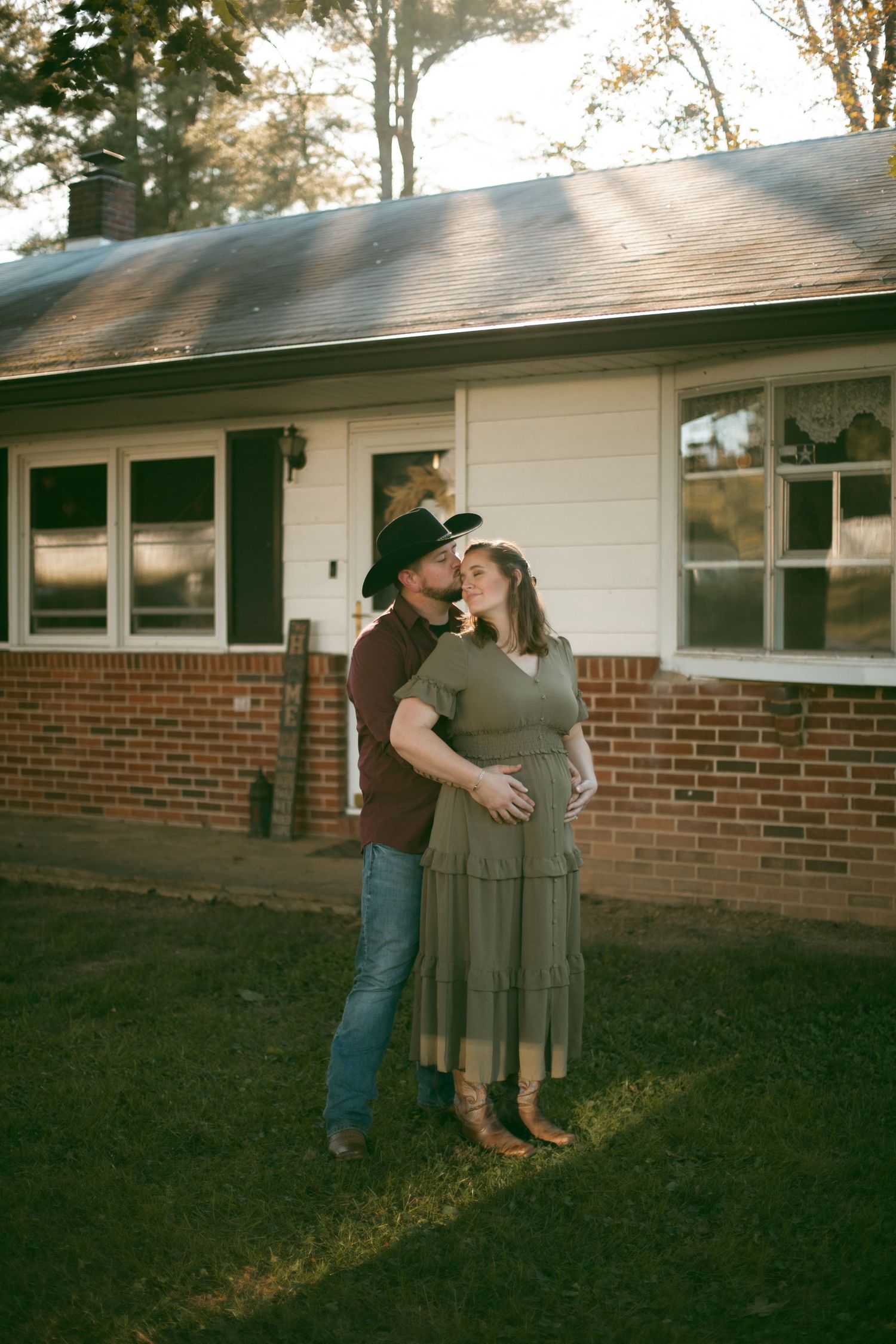 Couple dancing together outside a brick ranch house at dusk.