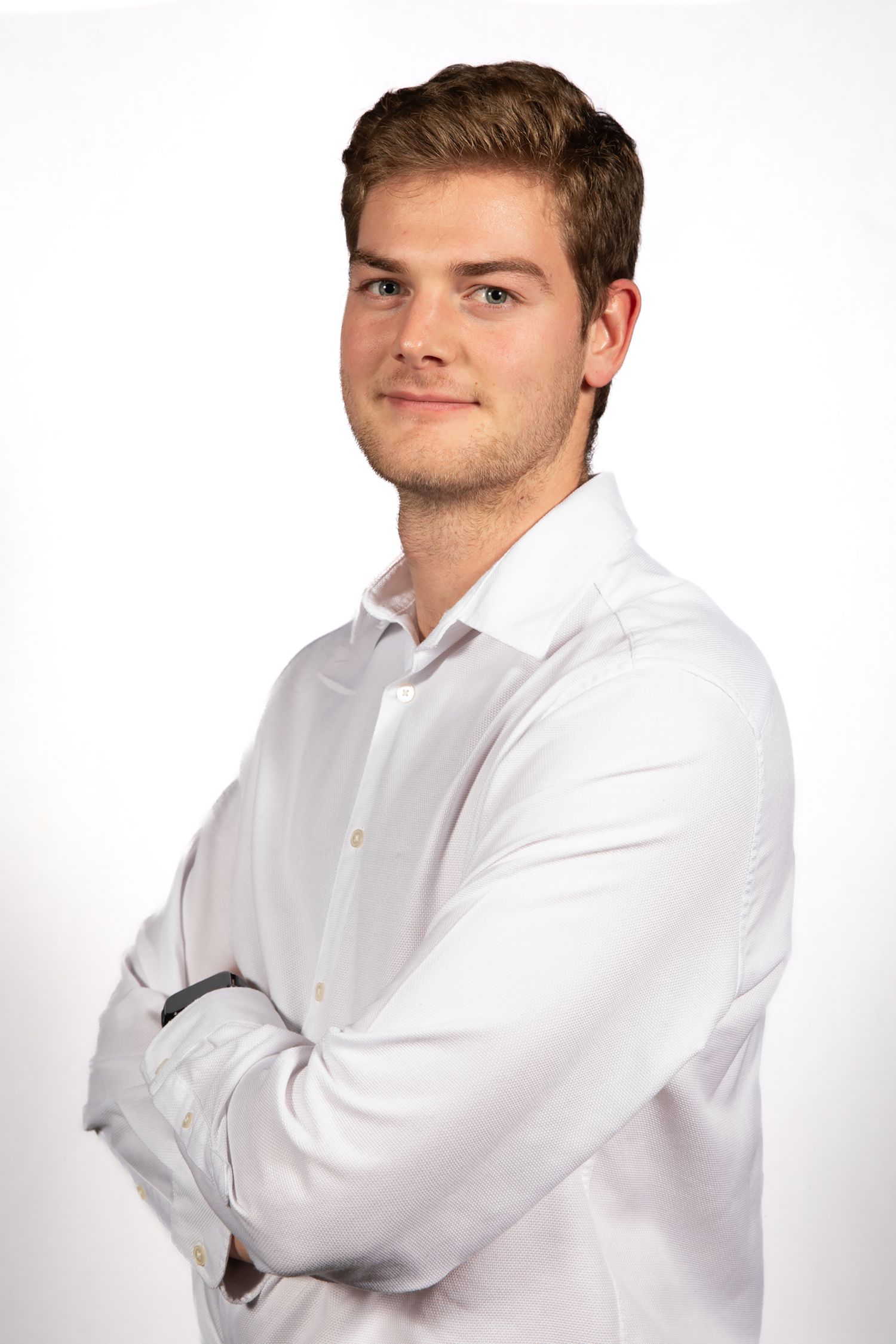 Professional headshot of someone in a crisp white dress shirt against a white background.