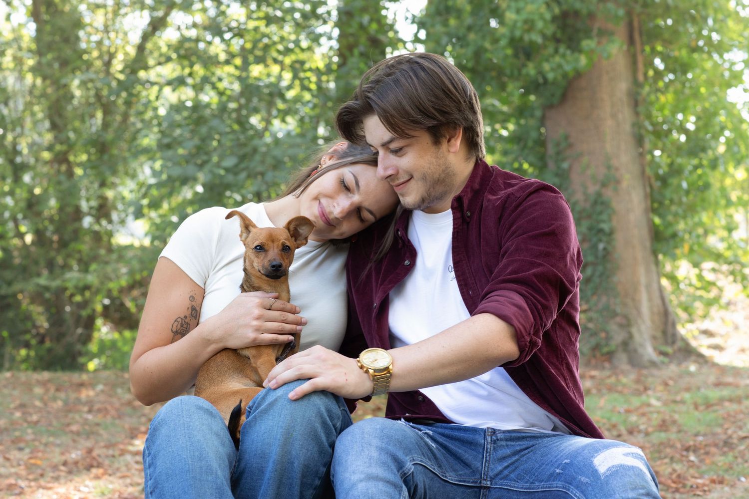 Couple relaxing together on grass in a scenic park setting.