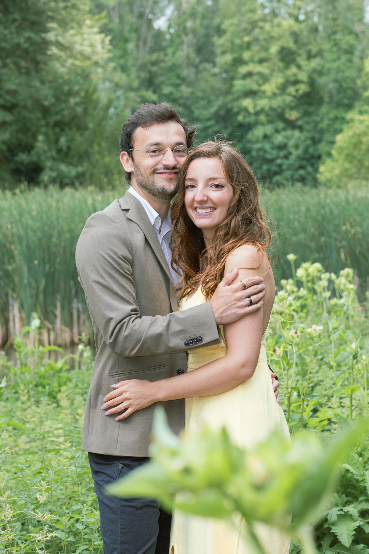 A tender embrace captured in a lush summer garden with natural lighting.