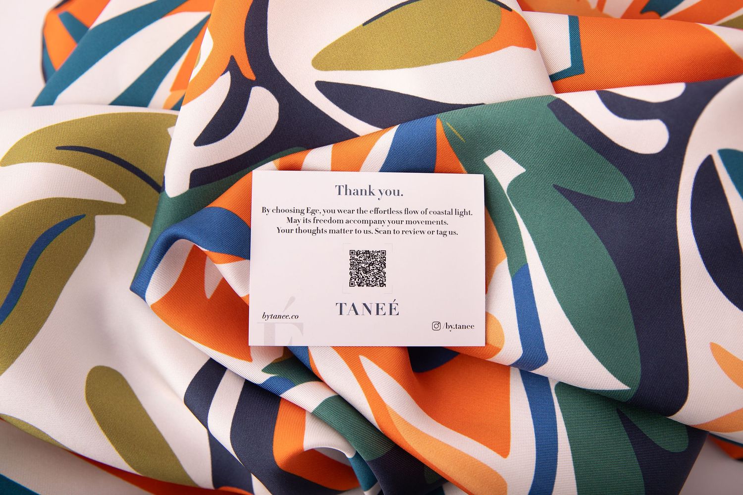 Colorful abstract paper shapes create a dynamic geometric pattern with orange, blue, and white curves.