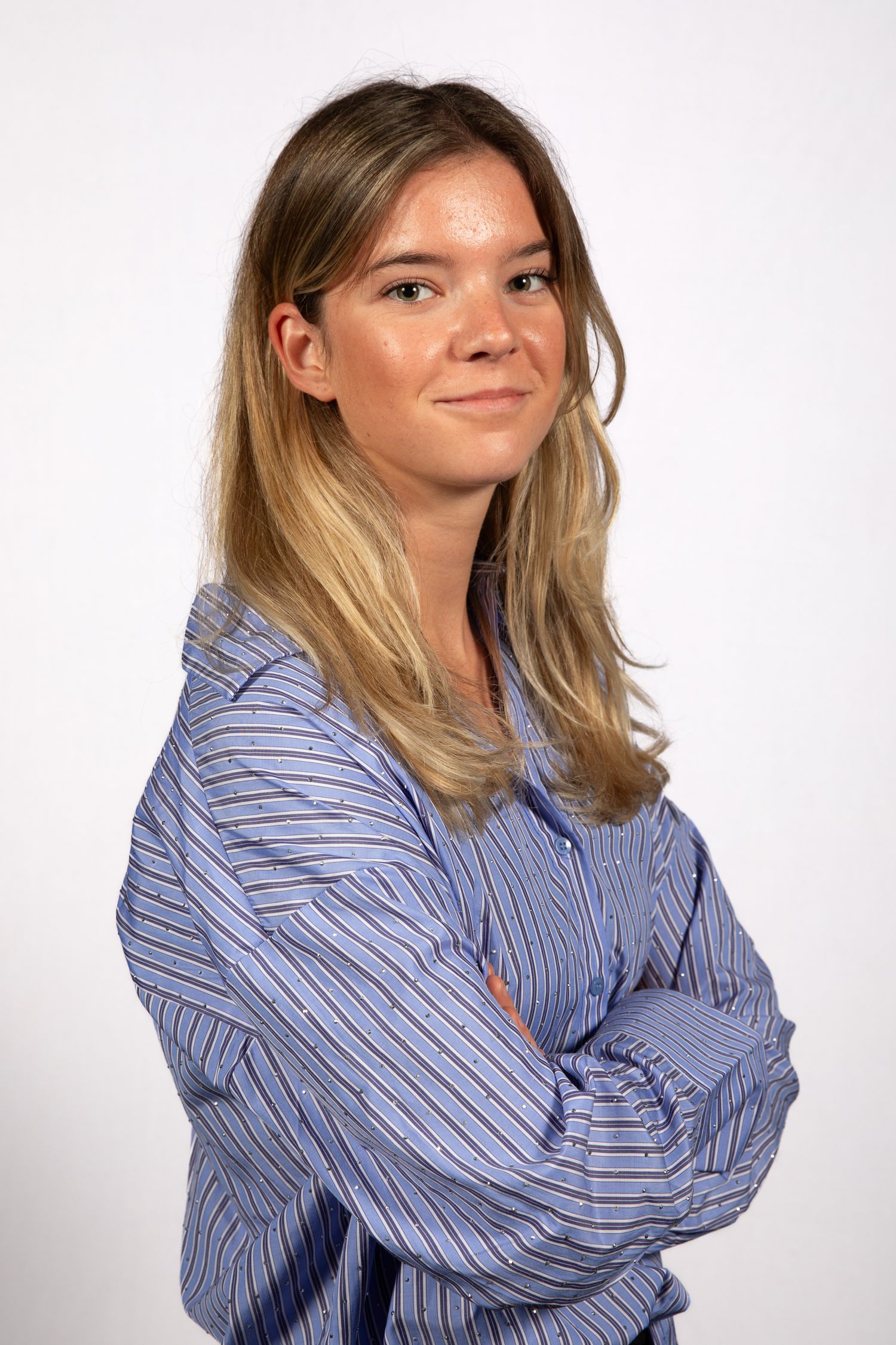 Professional studio portrait of someone wearing a blue striped button-down shirt against white background.