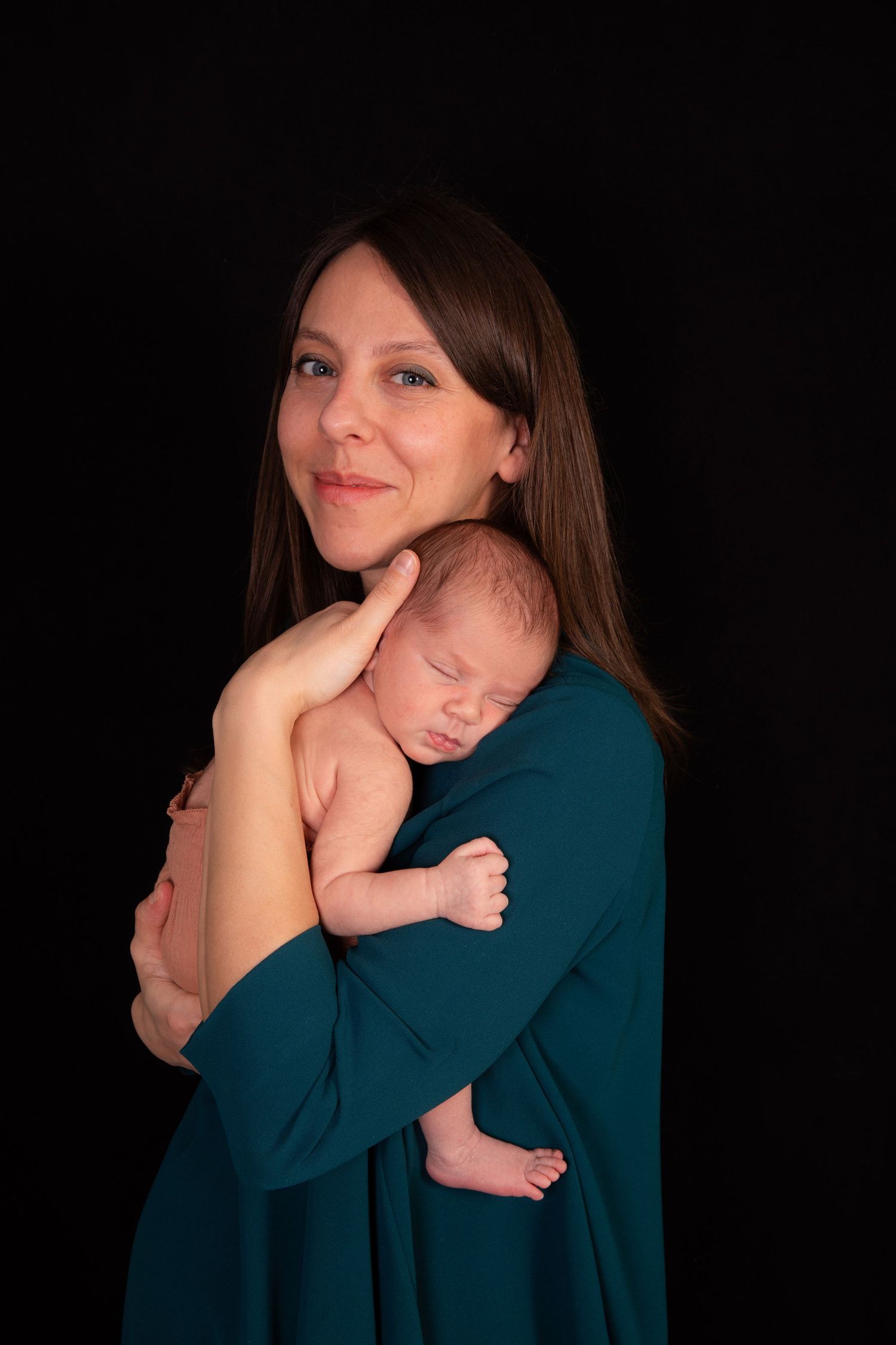 Series of intimate mother and newborn portraits against black background.