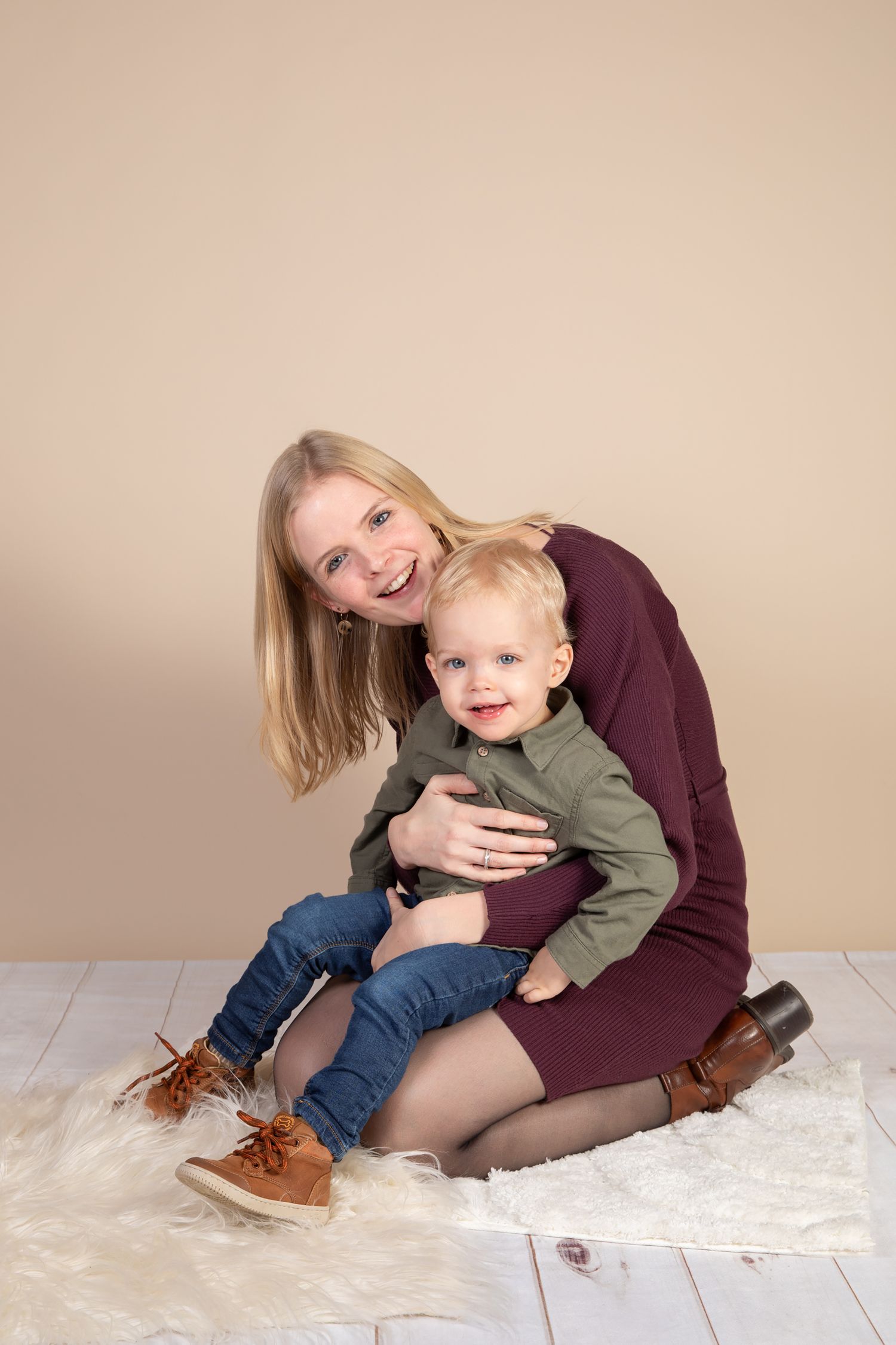 A series of tender moments captured between a parent and child sitting on a white fluffy rug in casual clothing.