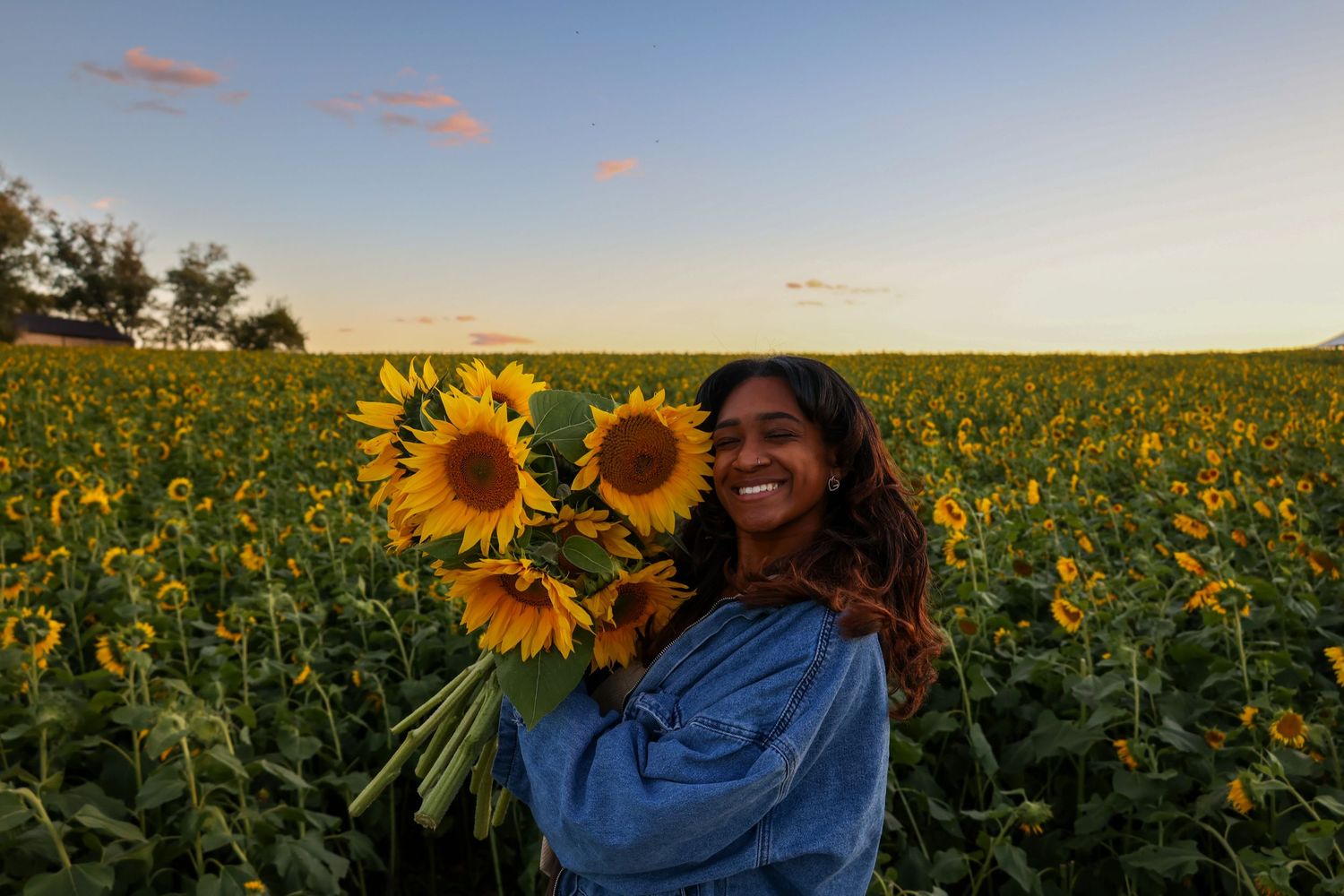 Vibrant sunflower field at sunset with joyful poses among the tall yellow blooms.