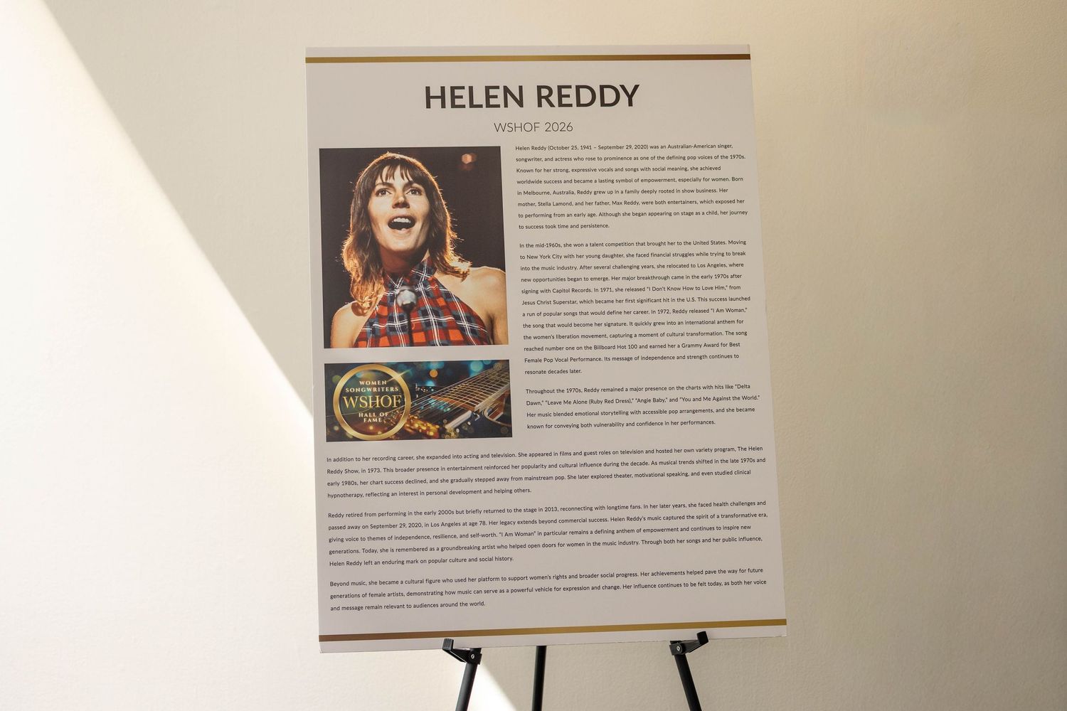 Helen Reddy biography display board on an easel at an exhibition or museum event.