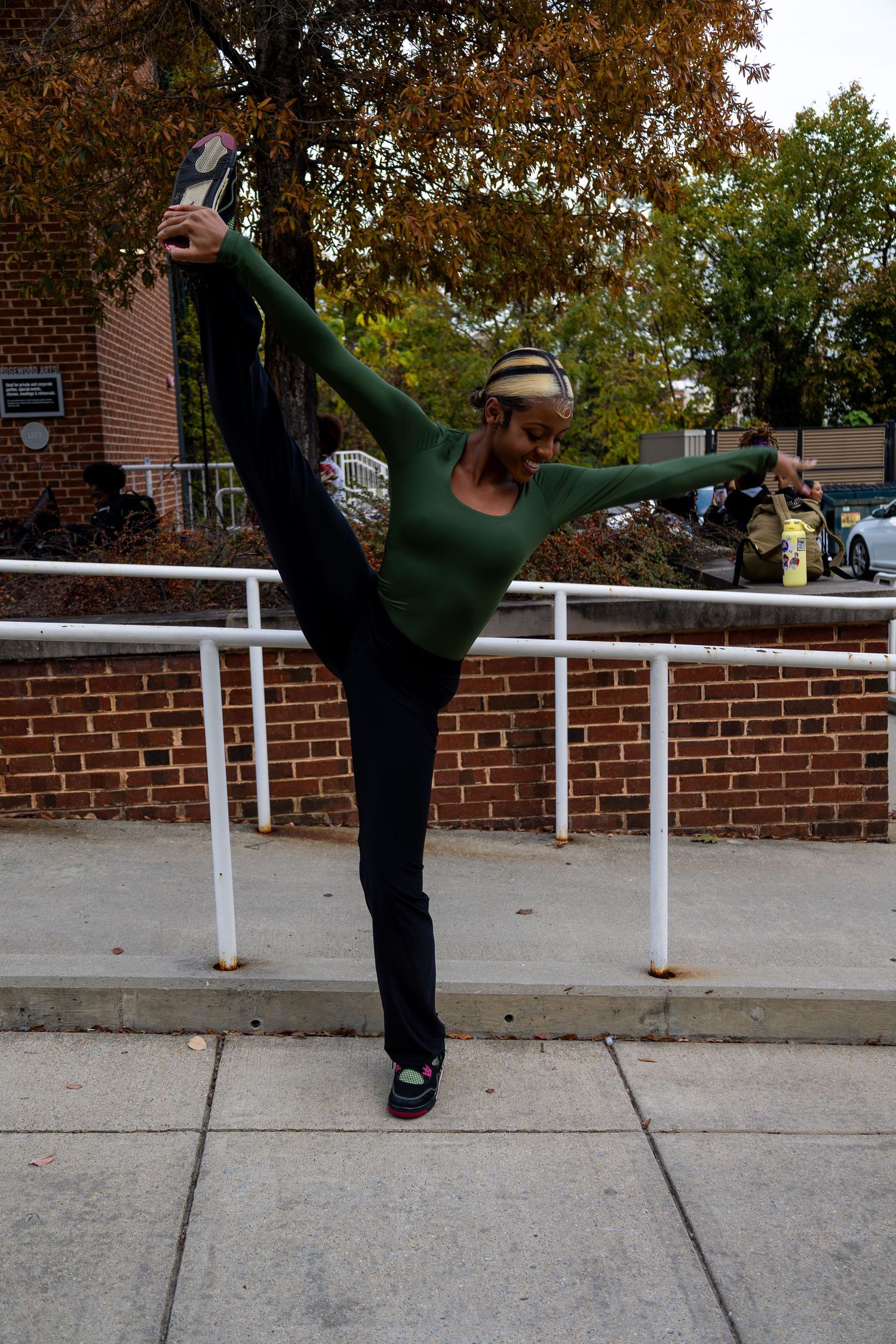 Sequential shots of a high kick demonstration against a brick wall with white railing.