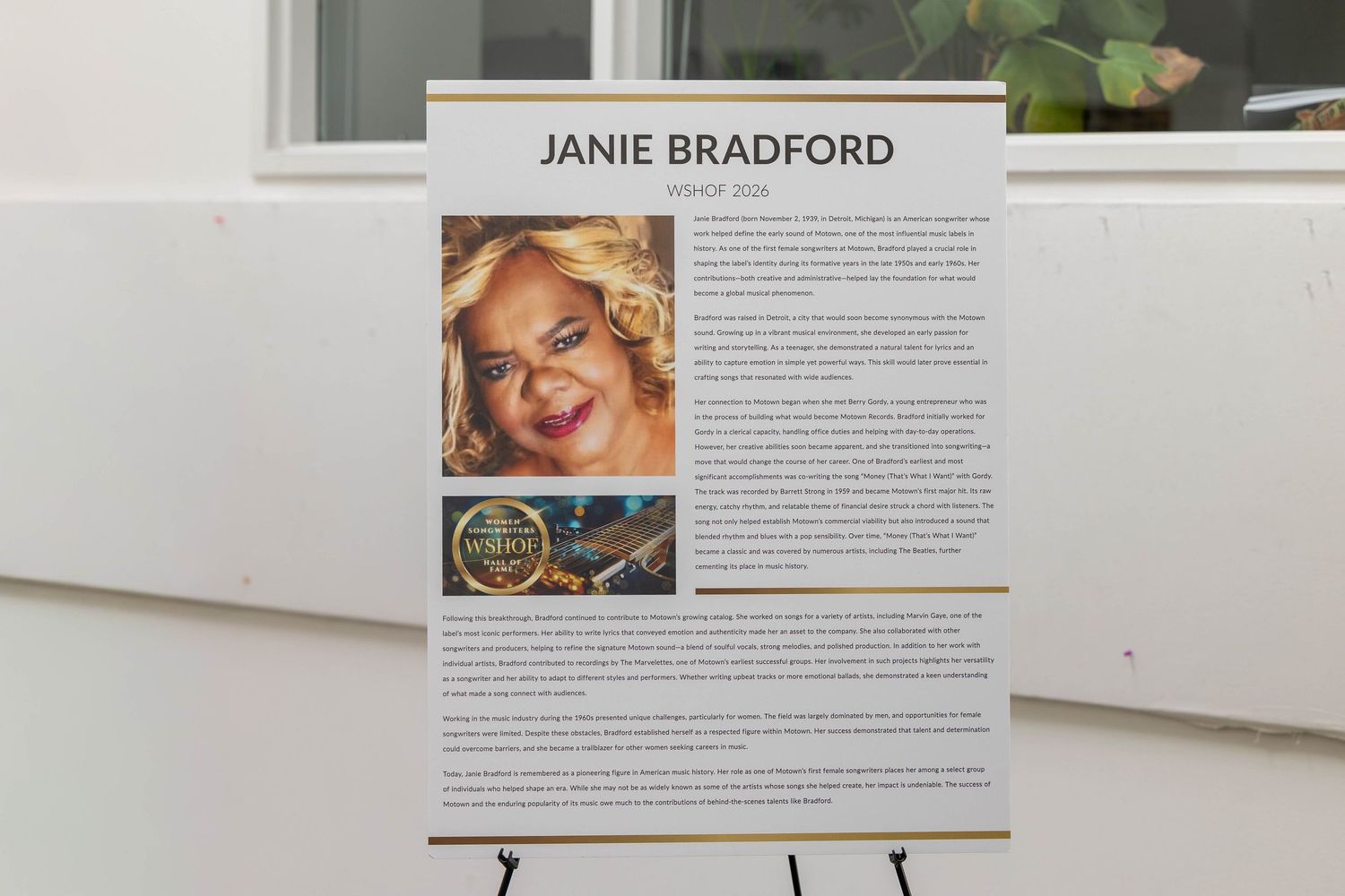 Award display board honoring Janie Bradford on an easel at a formal recognition event.