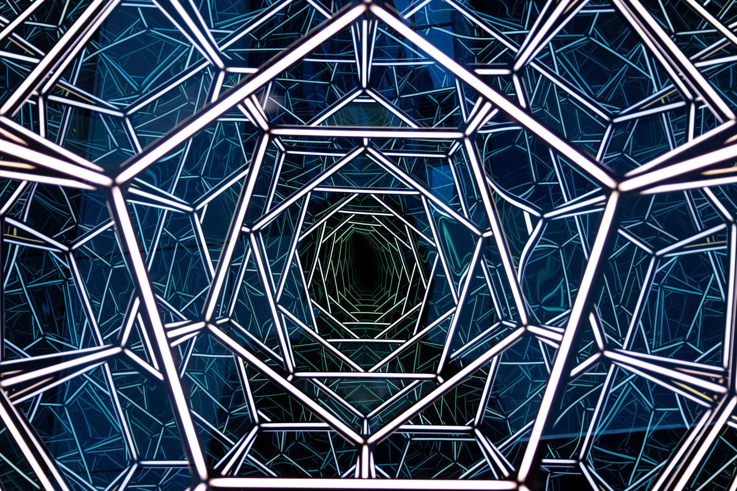 A mesmerizing geometric tunnel with glowing neon blue and white pentagon shapes receding into darkness.