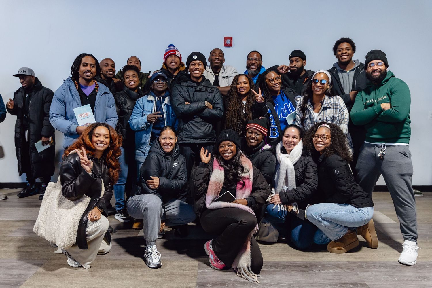 Group of students sitting together on concrete steps outdoors for a casual photo.