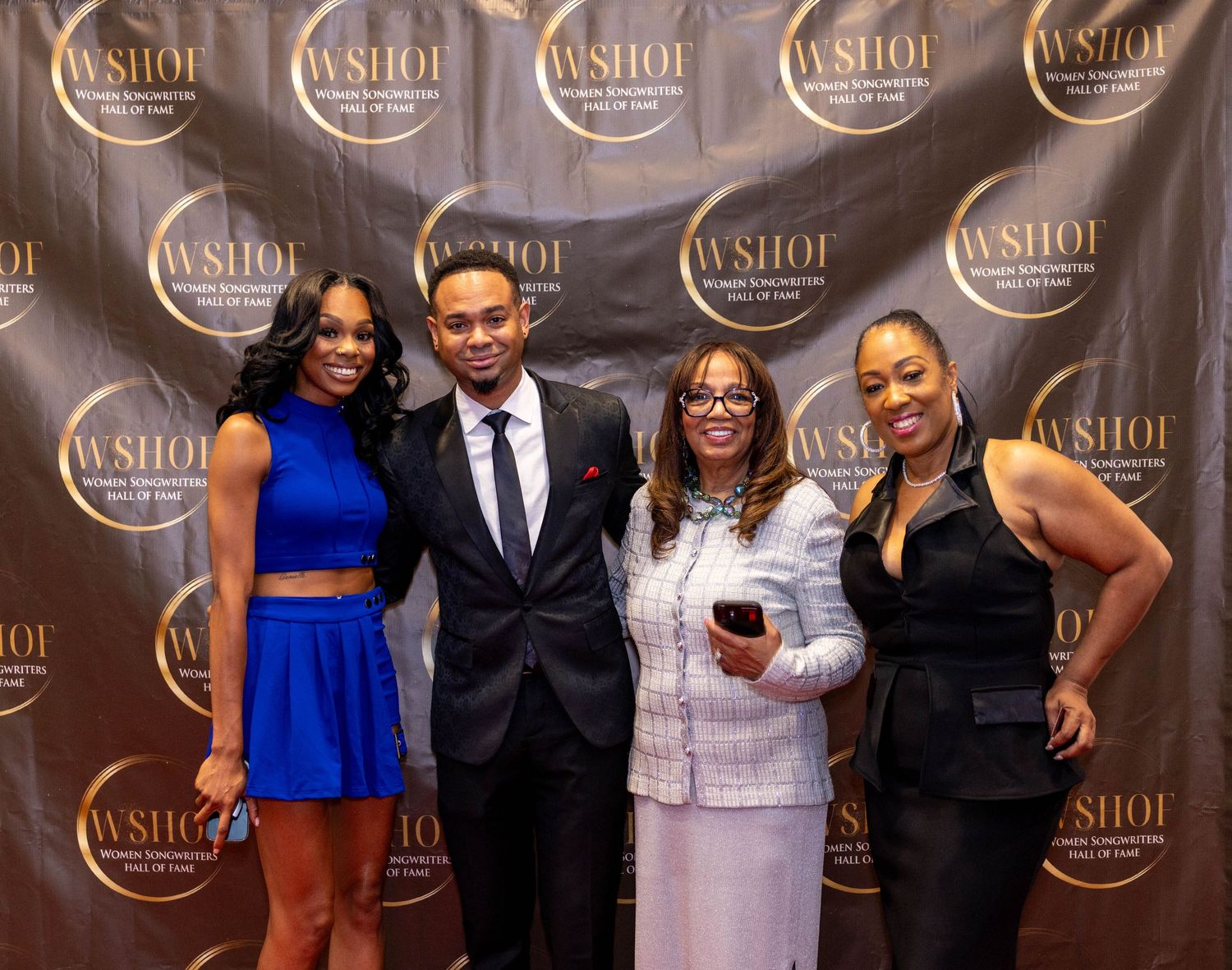 Four people posing together at a WSHOF event backdrop, dressed in formal attire at an elegant awards ceremony.