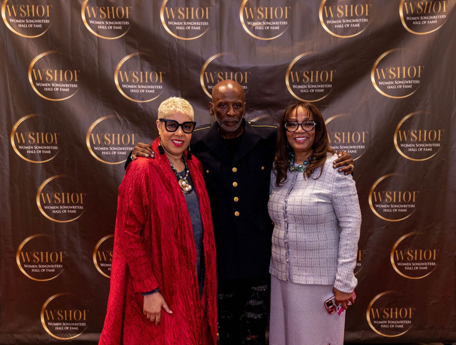 Three people posing together in front of a WSHOF step-and-repeat backdrop at a formal awards event.