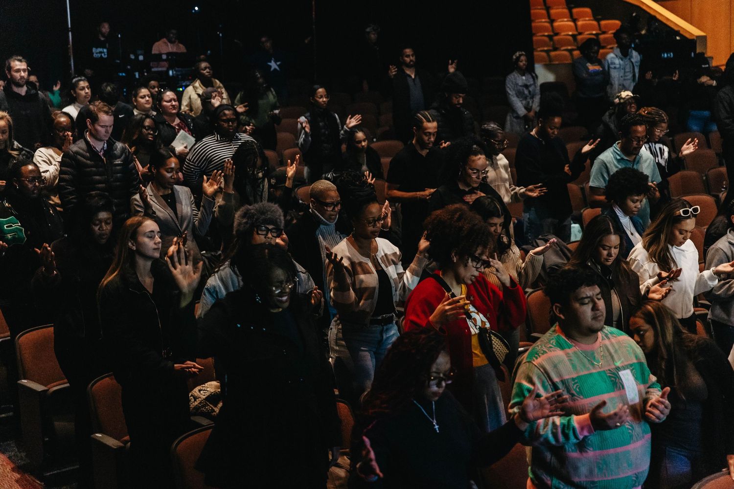 A large crowd of people gathered in a dark indoor venue for an event or performance.